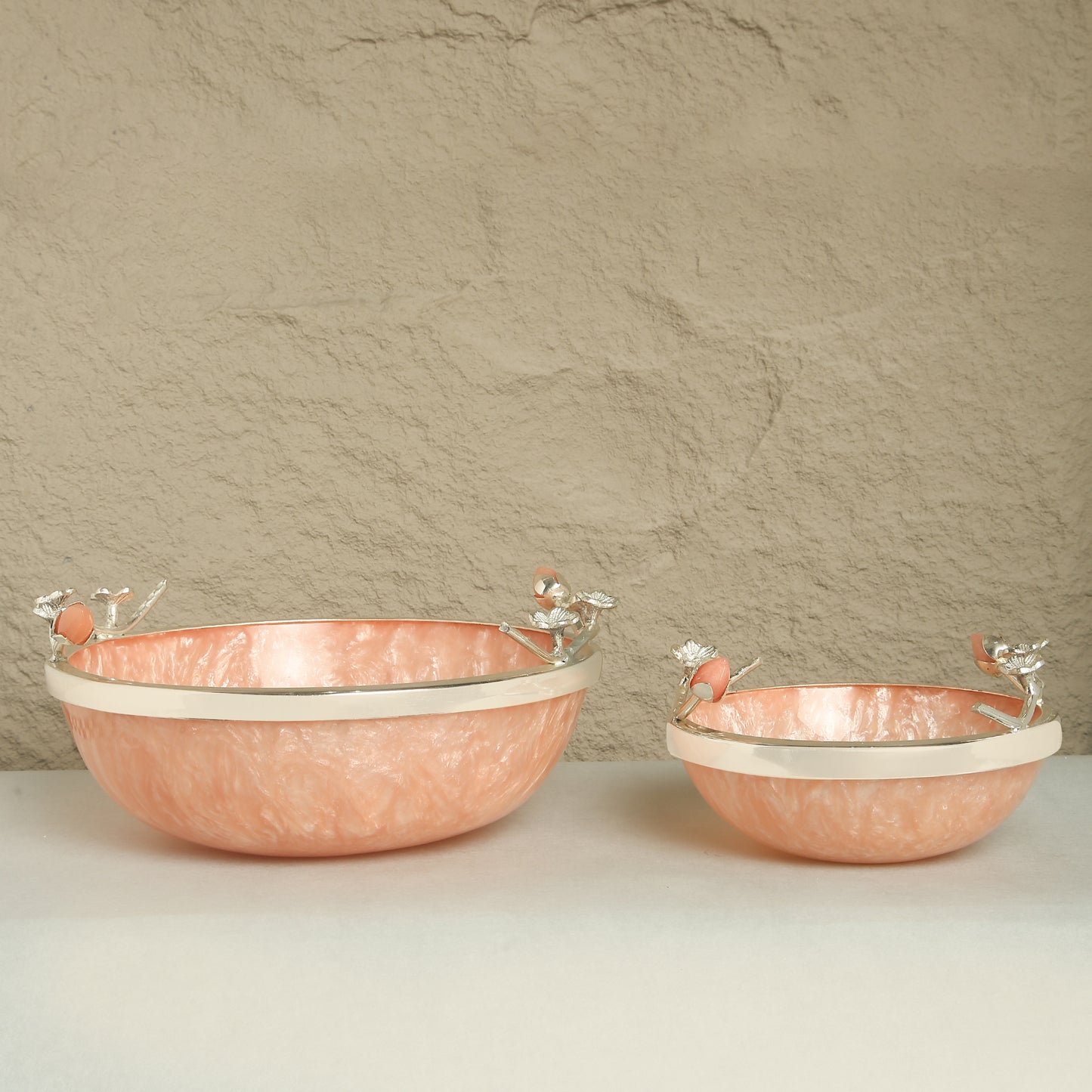 Two copper bowls with white interior on a beige background