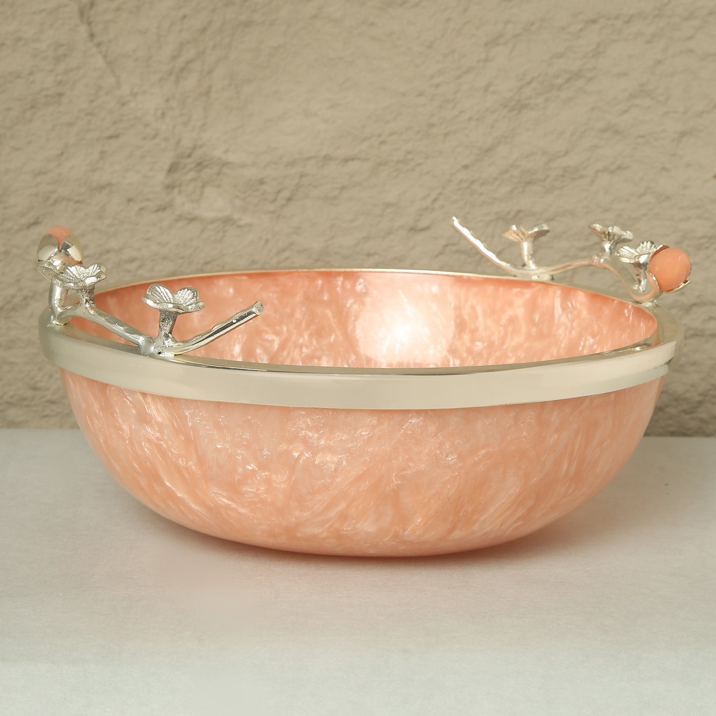 Copper bowl with decorative handles on a neutral background