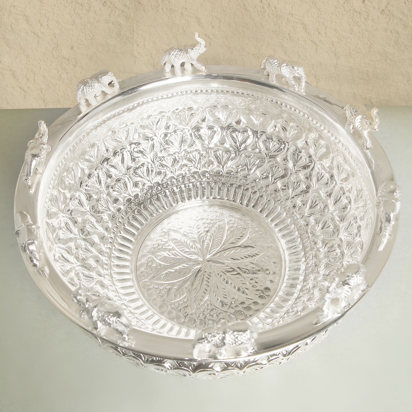 Decorative silver tray with intricate patterns on a light background