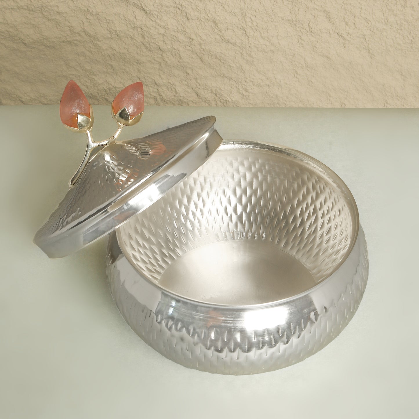 Silver textured container with a lid on a light background