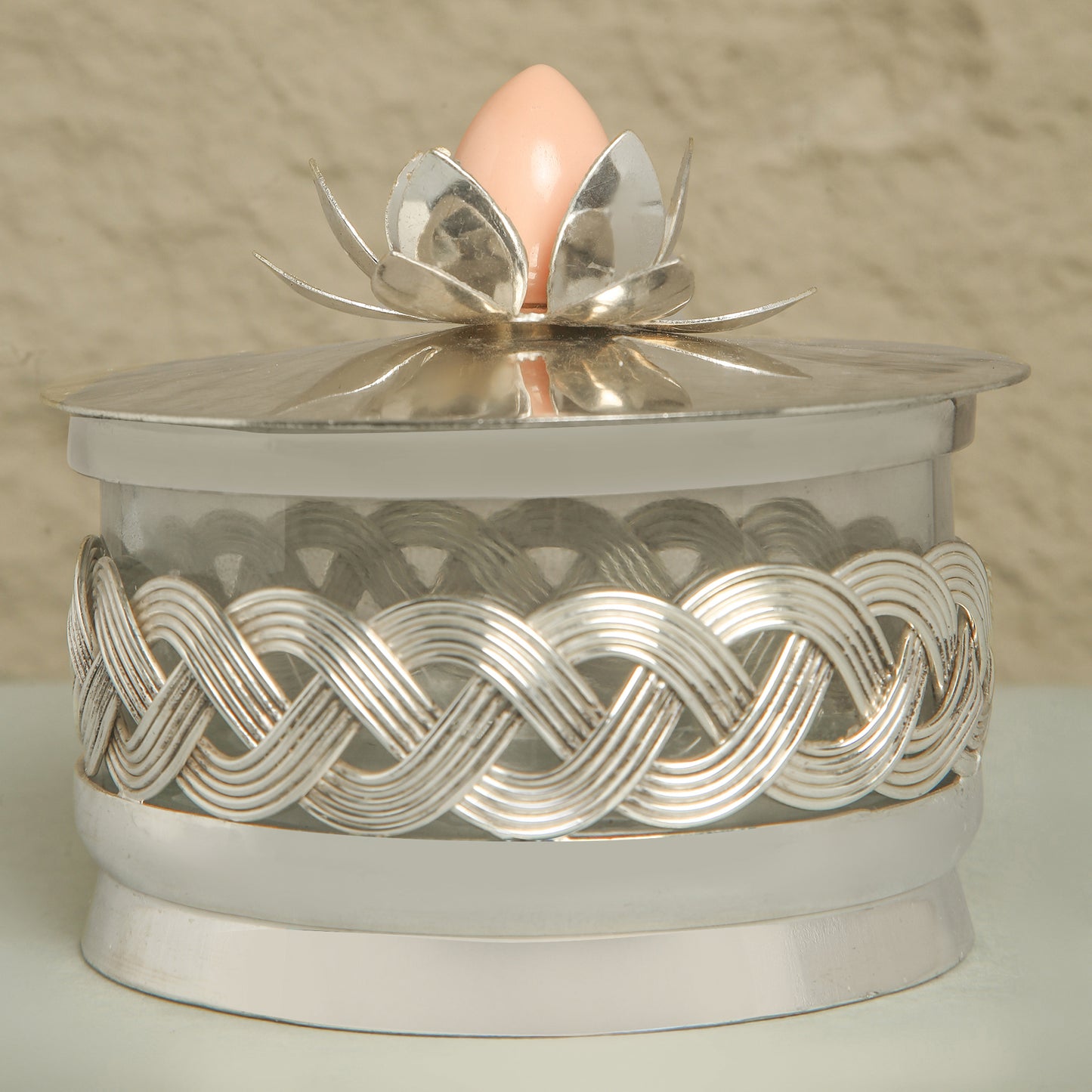 Decorative silver box with a pink egg on a beige background