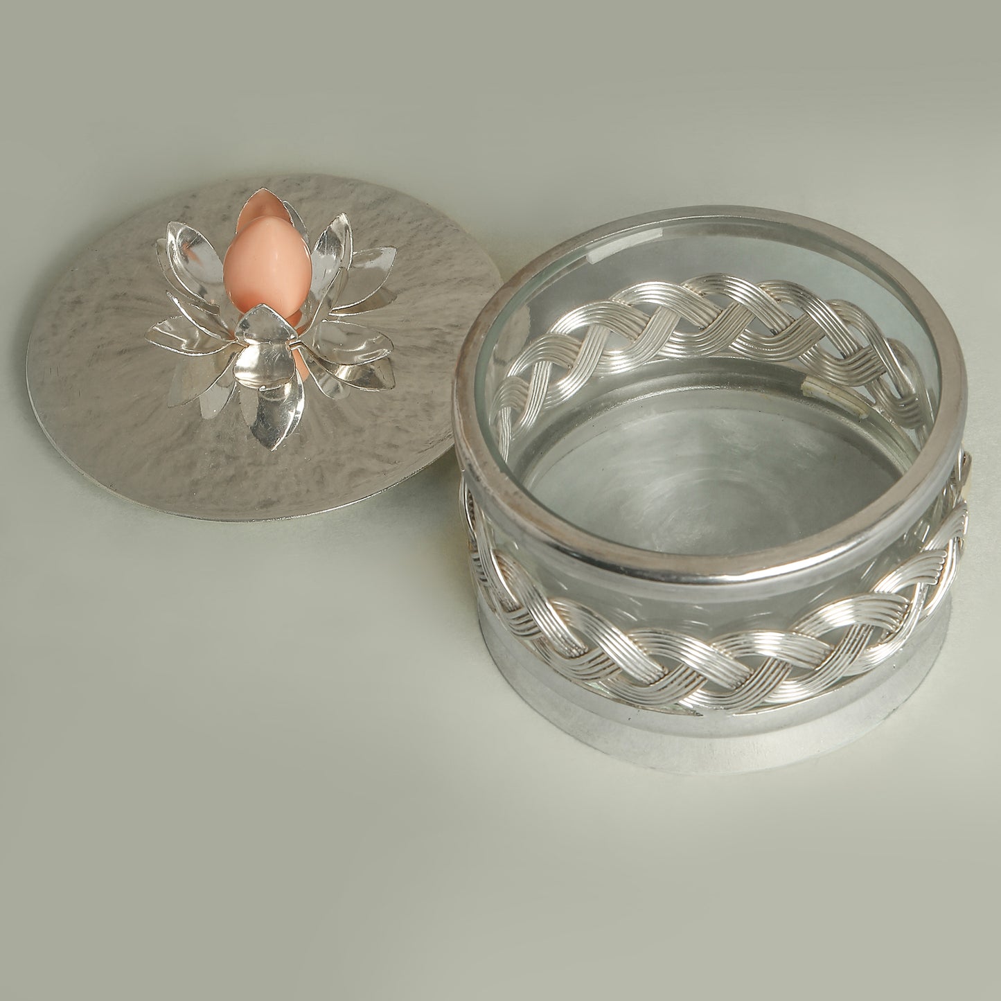 Silver jewelry box with a decorative lid on a light gray background