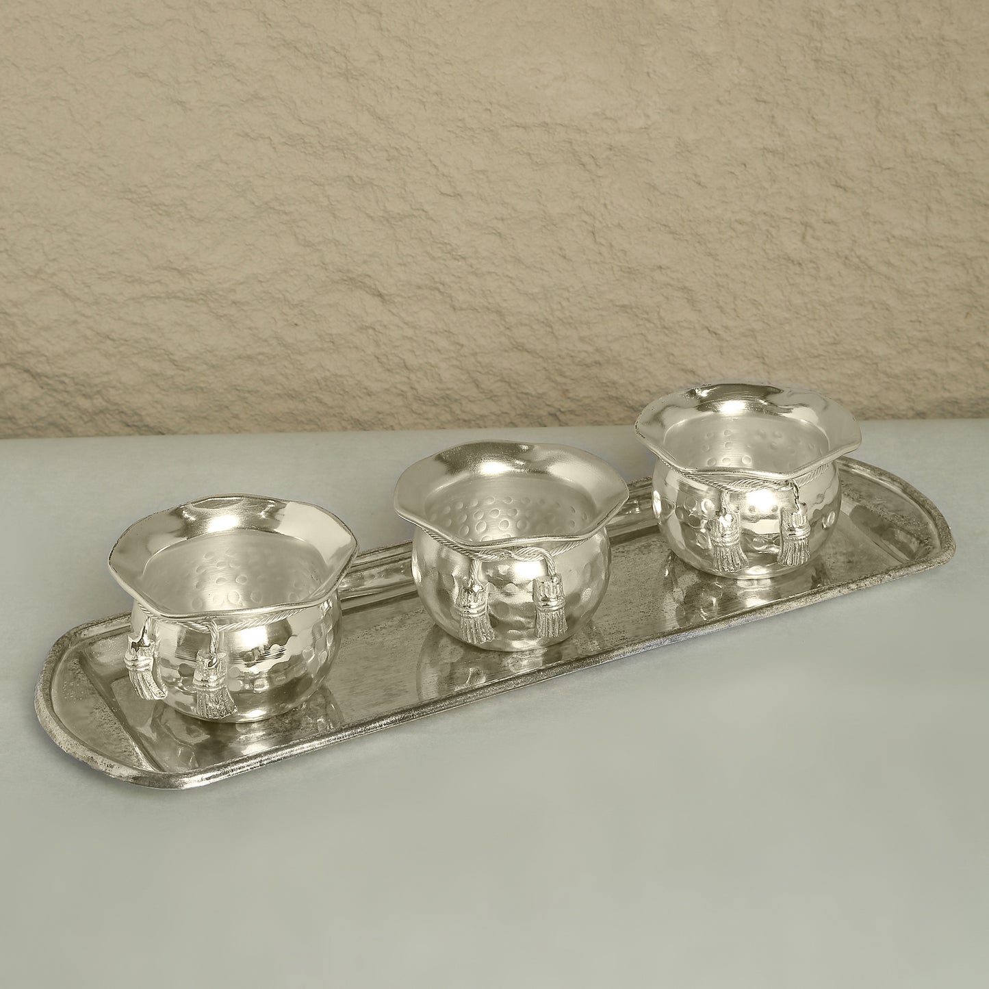 Set of silver tea cups and tray on a neutral background