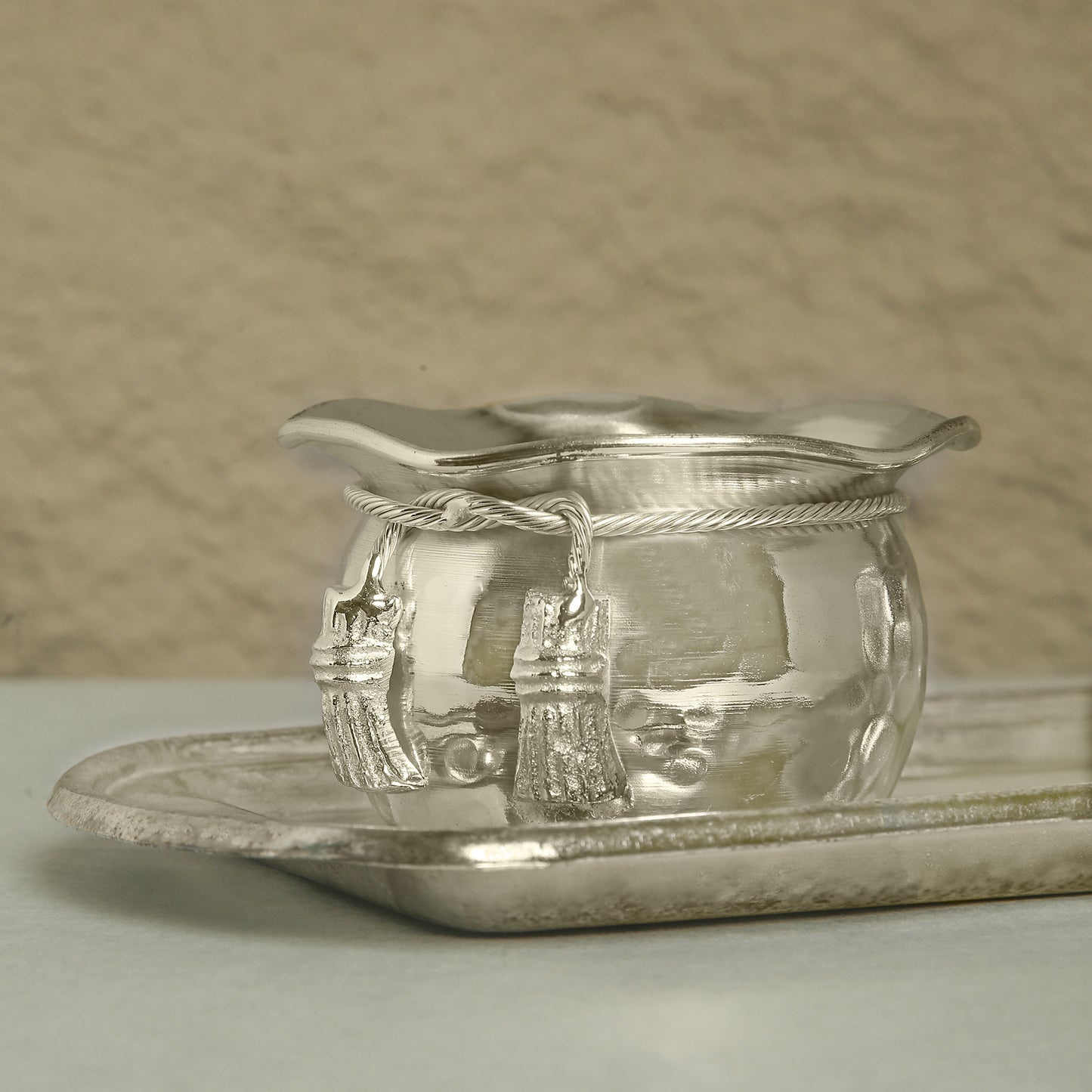 Silver dish with intricate designs on a textured surface