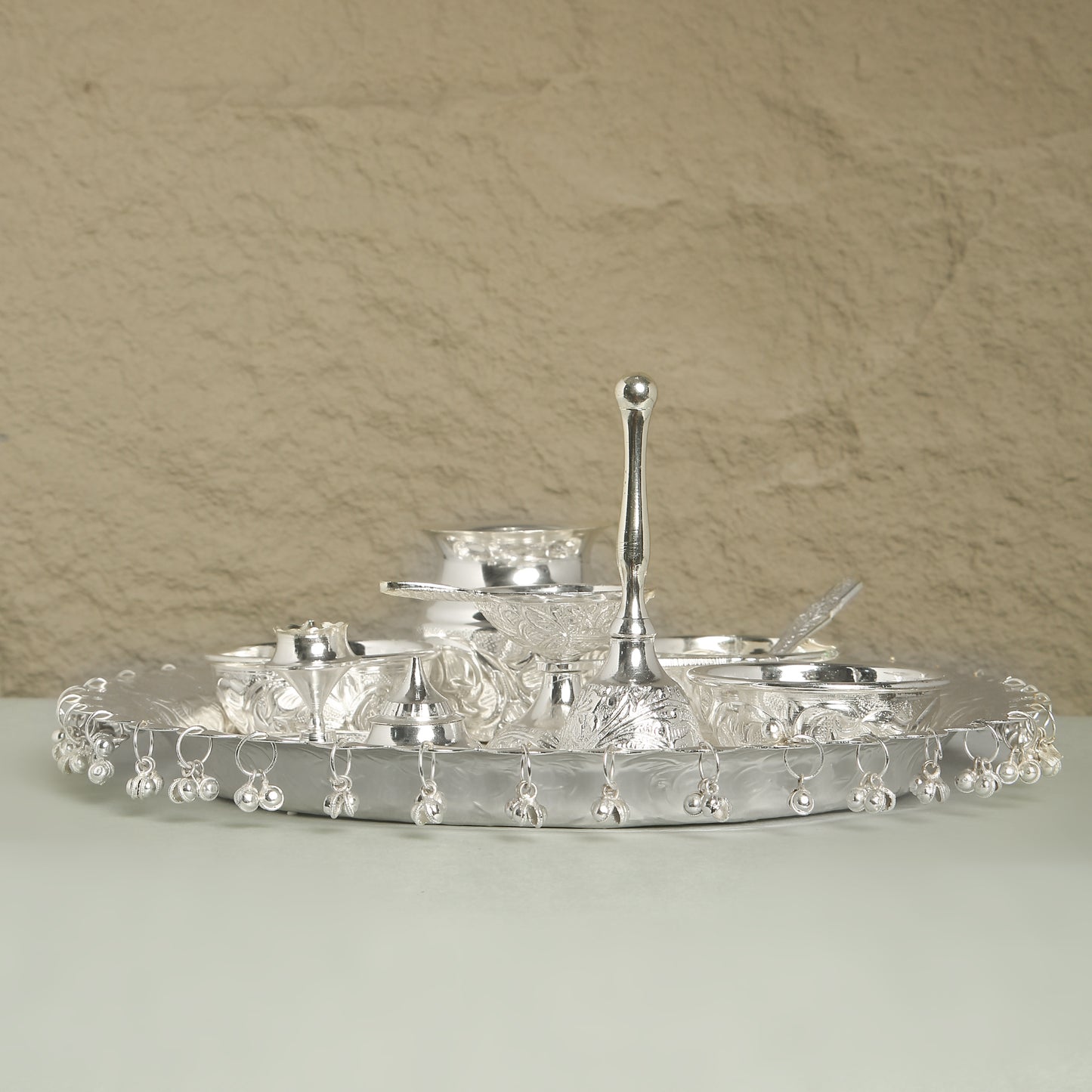 Silver tray with decorative elements on a beige background
