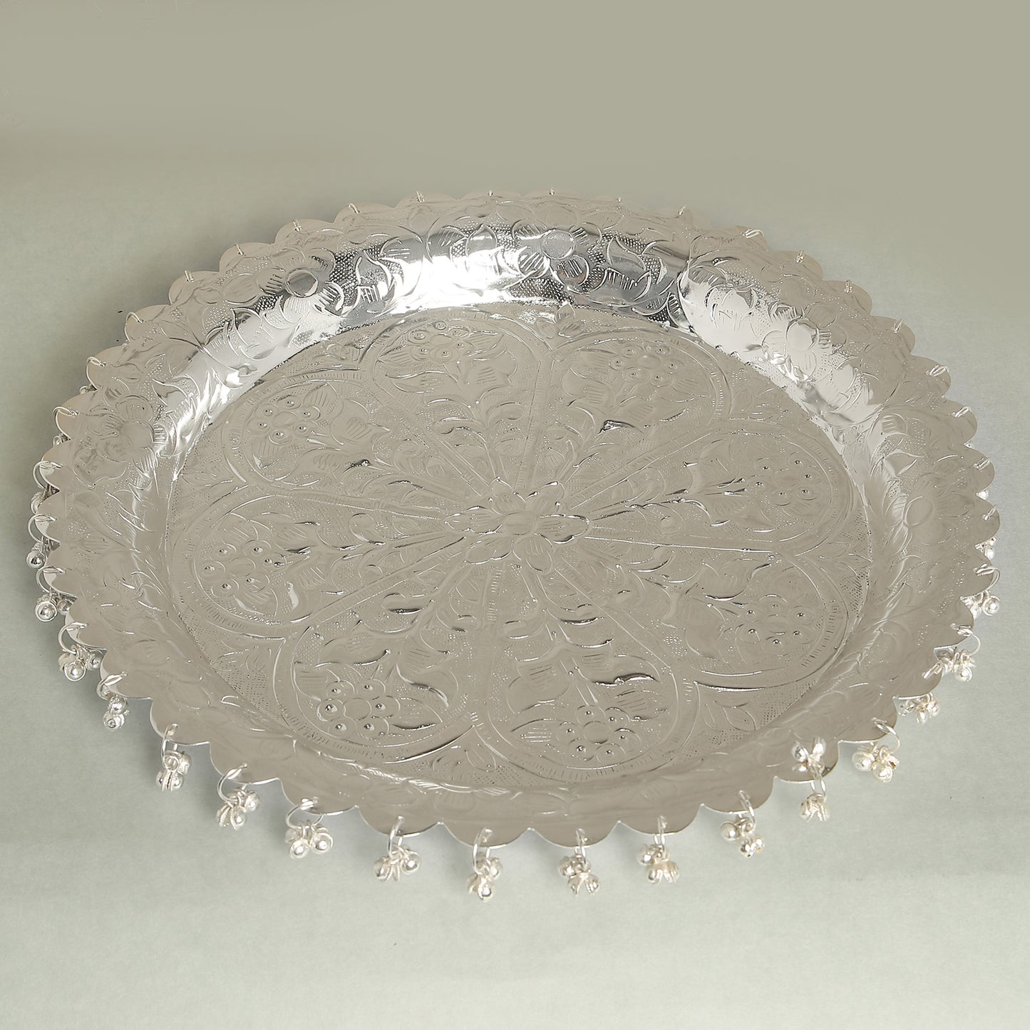 Decorative silver tray with intricate patterns on a light gray background