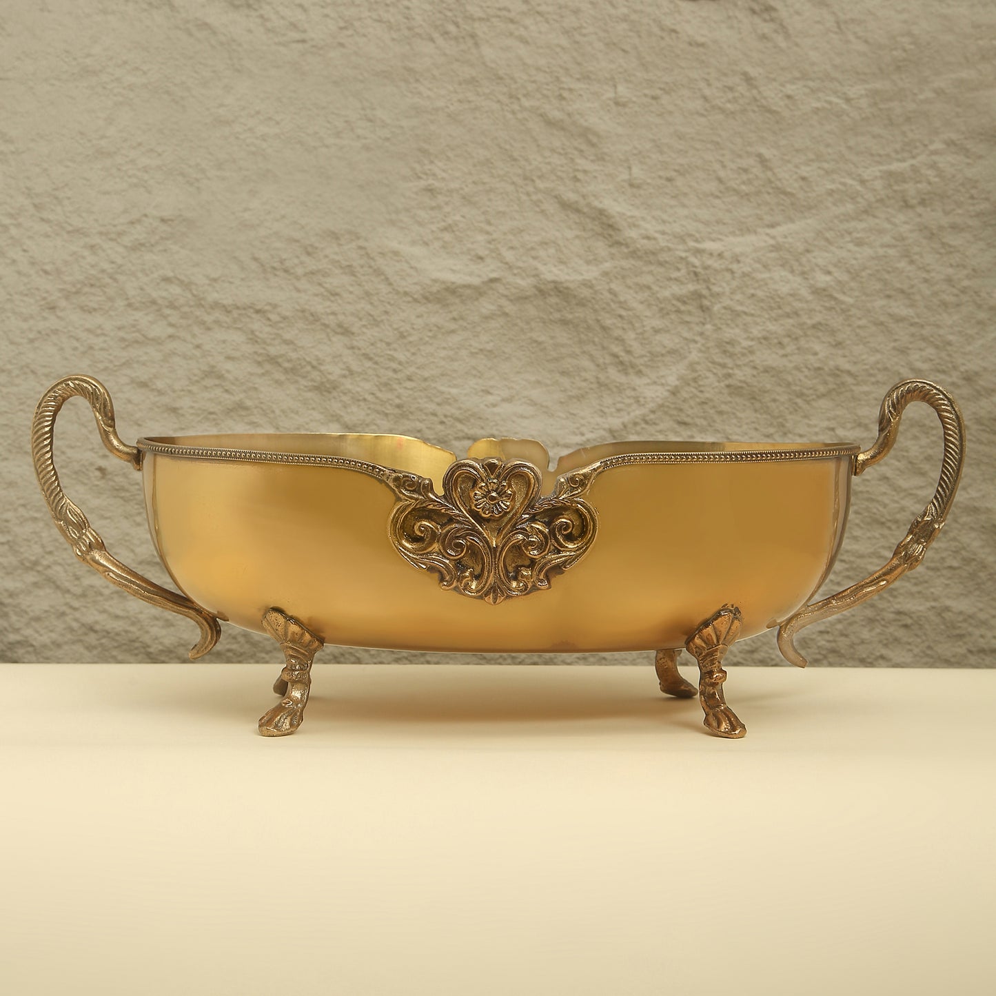 Decorative gold bowl with intricate designs on a beige background