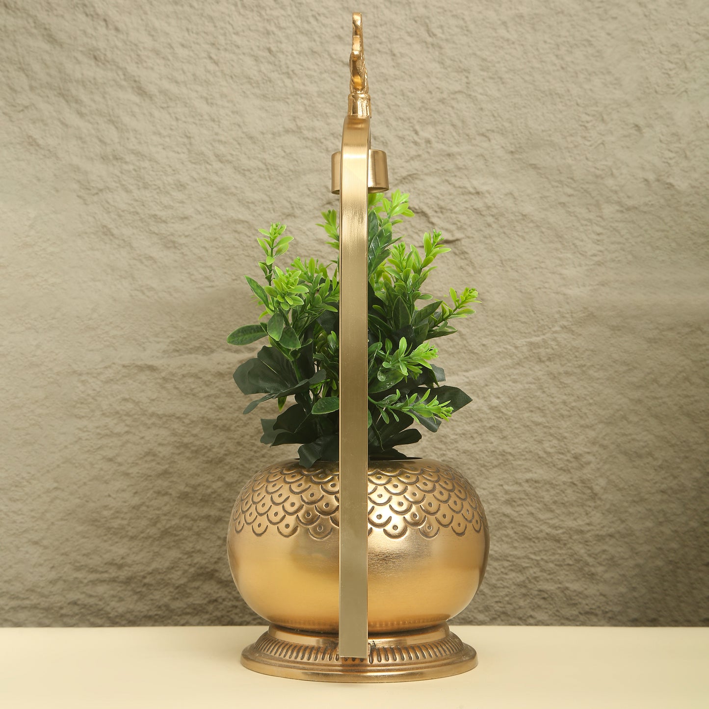 Decorative brass lamp with a plant on a textured beige background