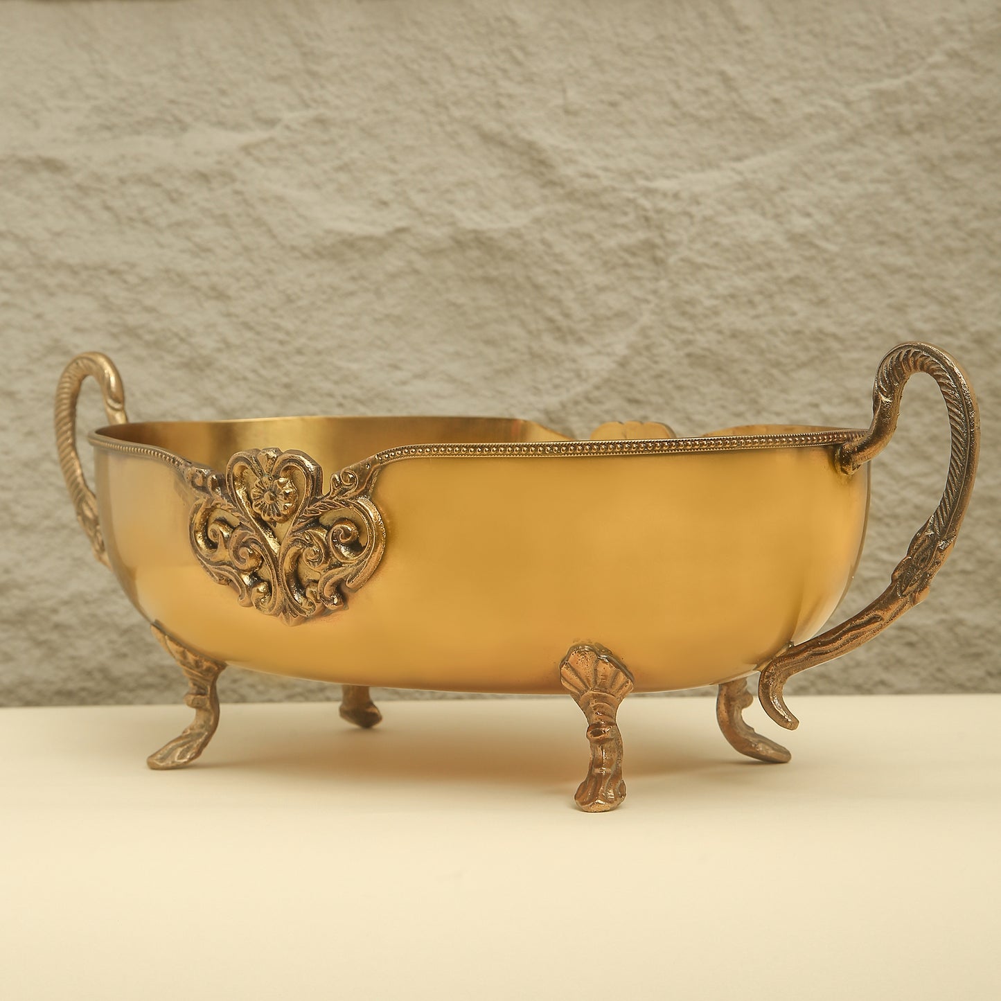 Decorative gold bowl with intricate designs on a neutral background