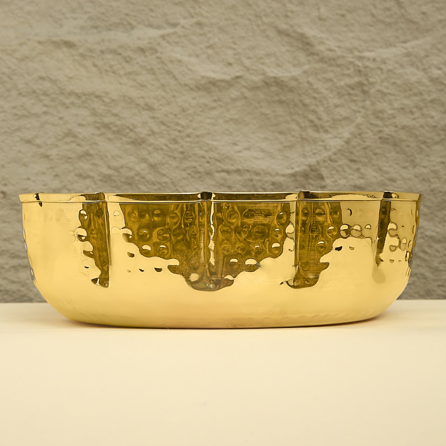 Gold bowl with textured surface on a neutral background