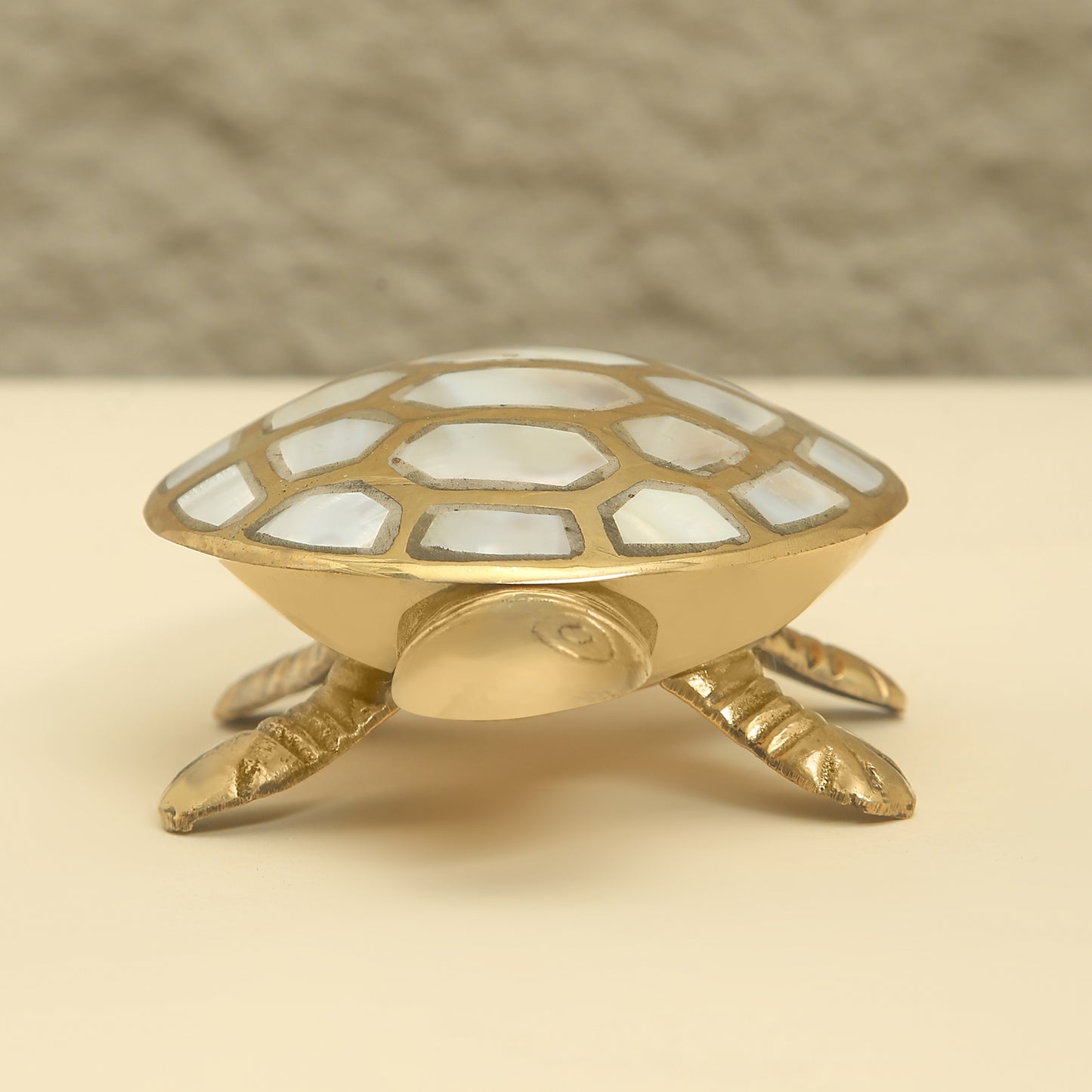 Decorative turtle figurine with mosaic shell on a beige background