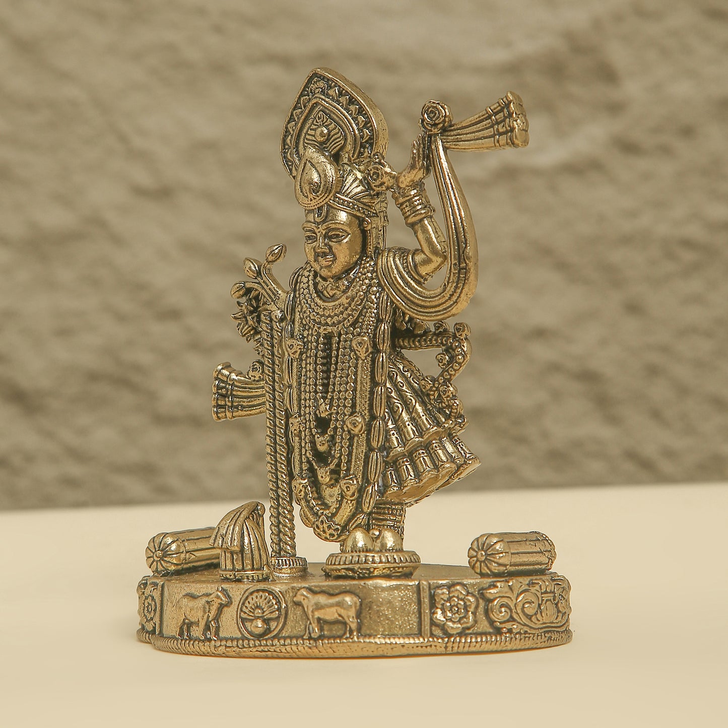 Bronze statue of a deity on a beige background