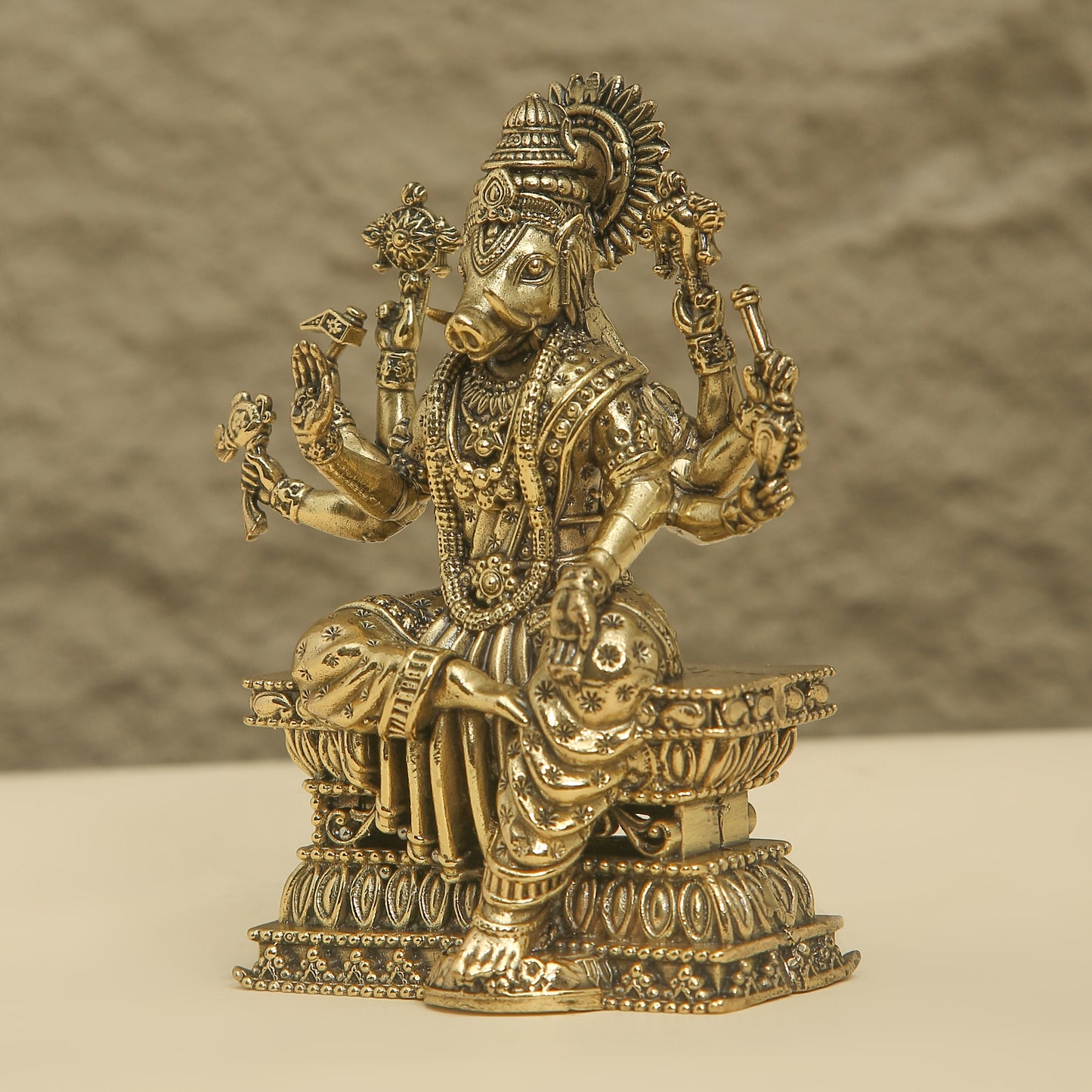 Decorative brass statue of a deity on a textured surface