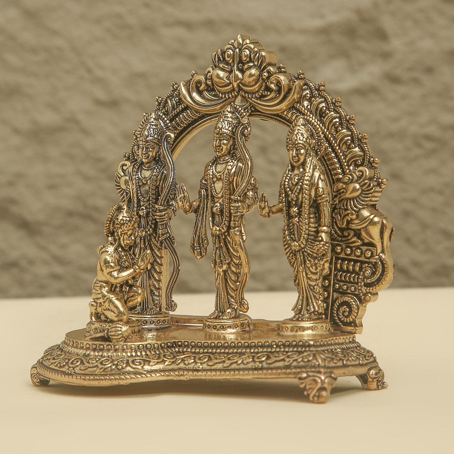 Decorative brass arch with figures on a beige background
