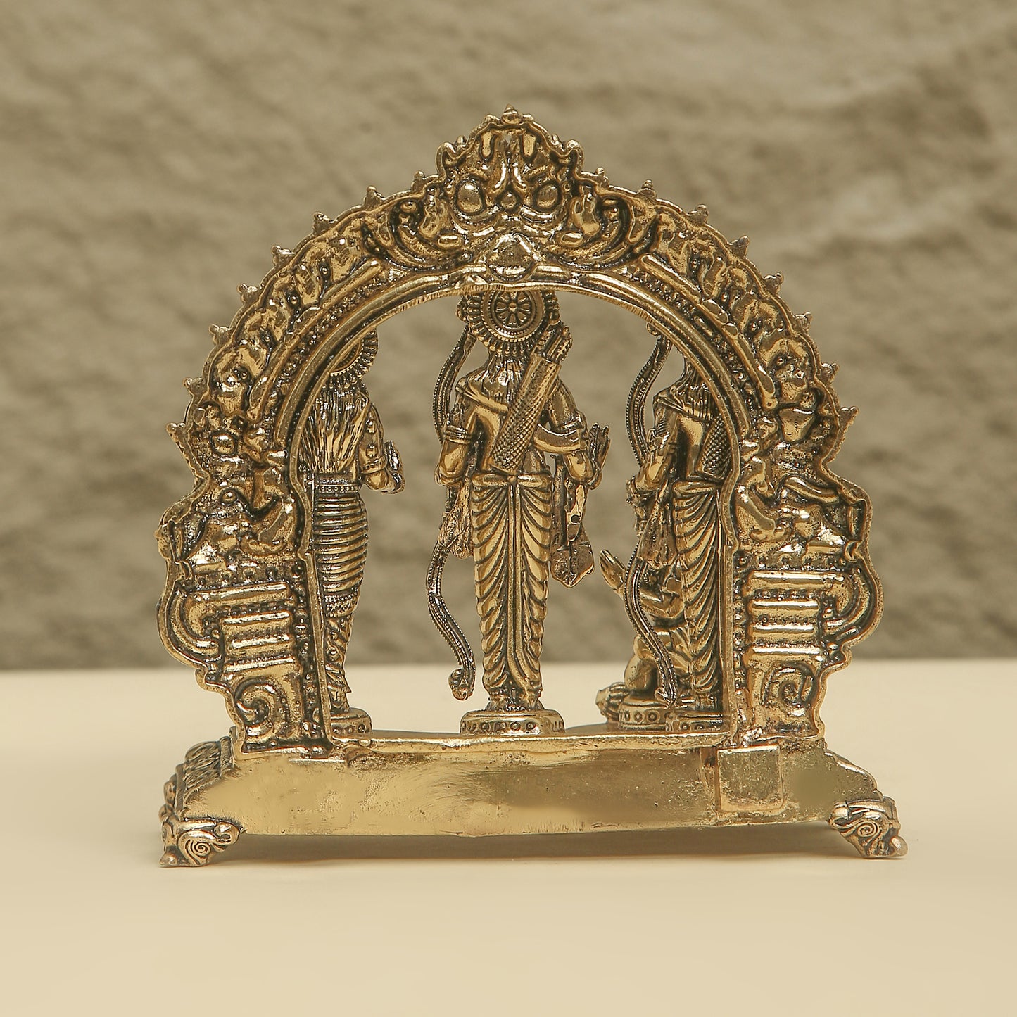 Decorative brass arch with figures on a beige background