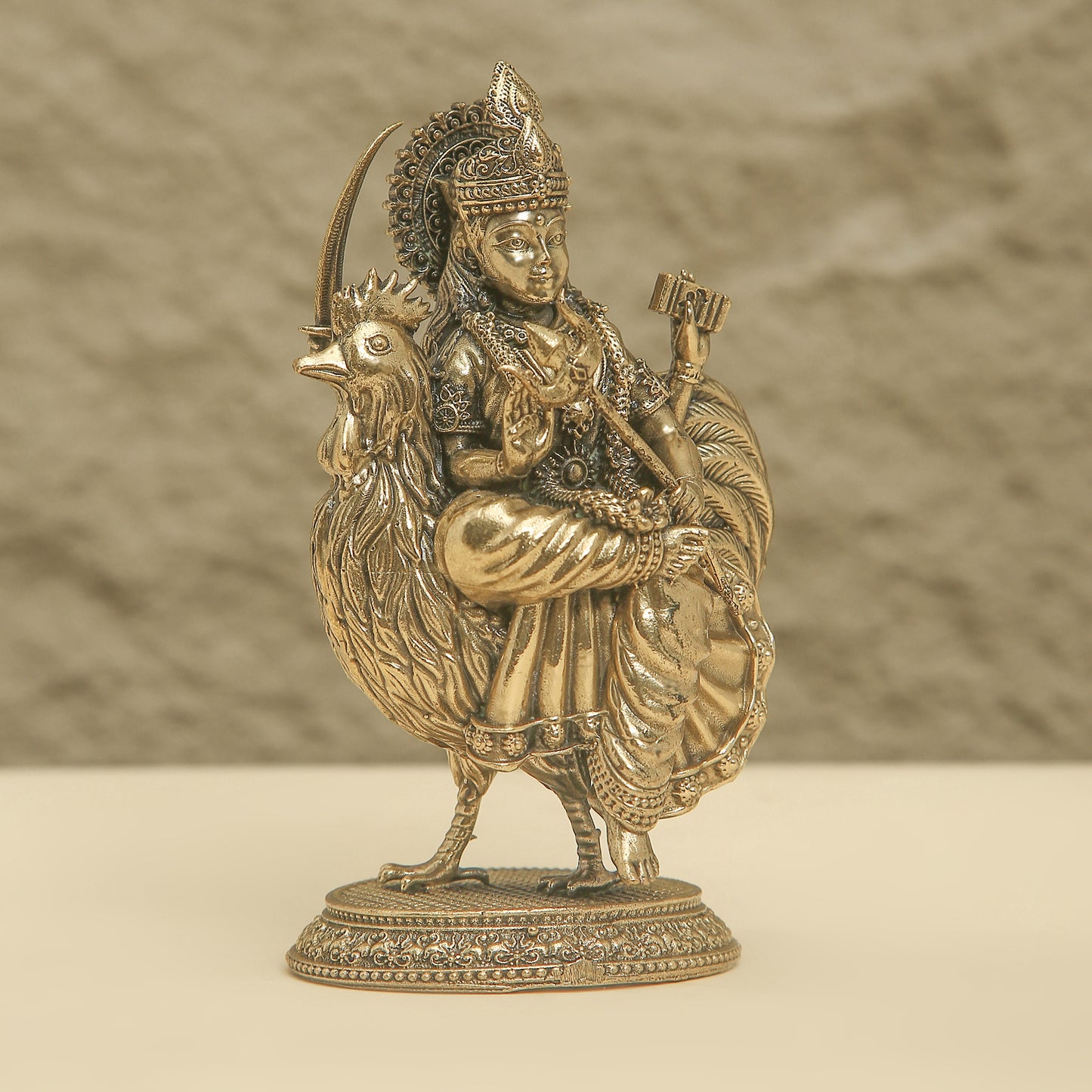 Bronze statue of a figure on a rooster with a textured background