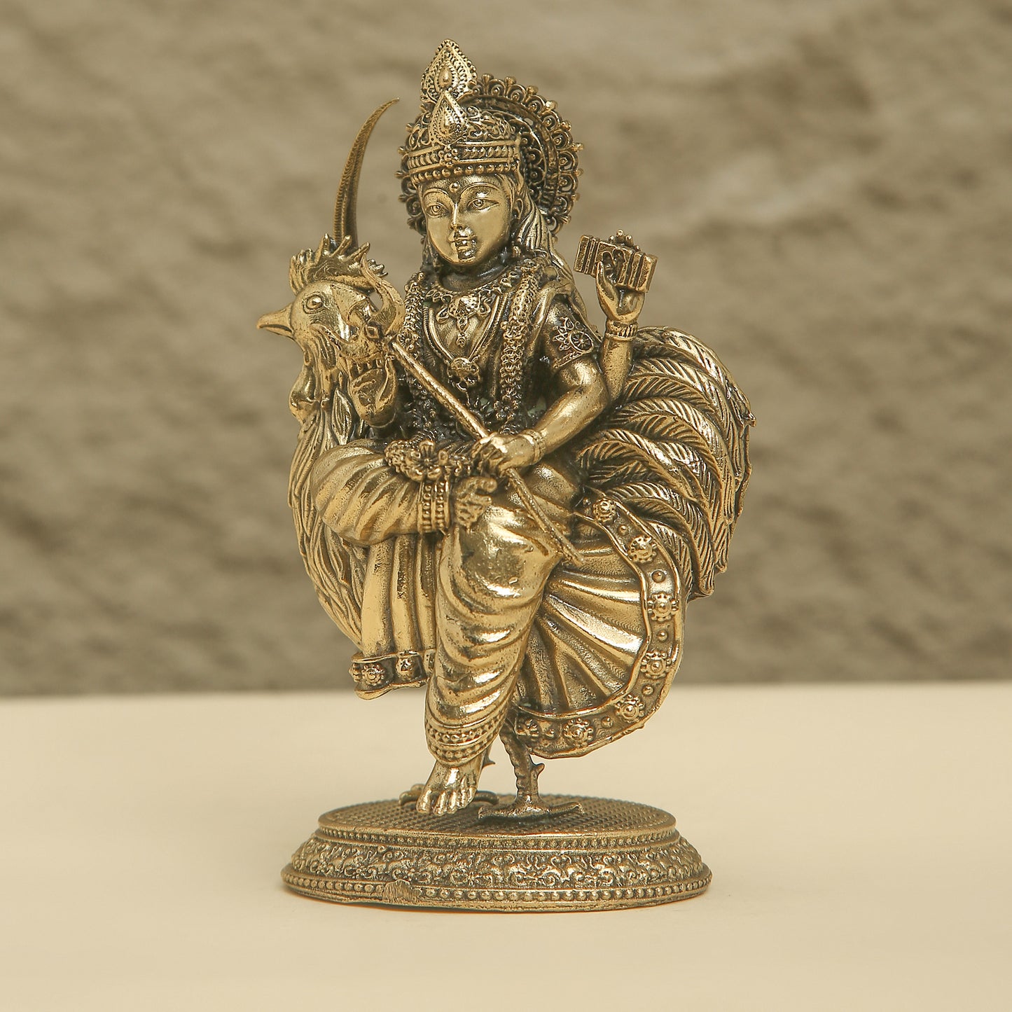 Bronze statue of a deity riding a goat on a beige background