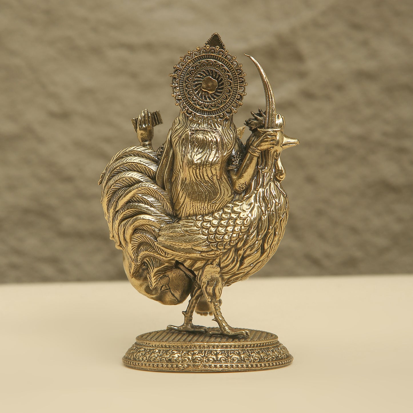 Bronze statue of a rooster with a helmet and sword on a beige background