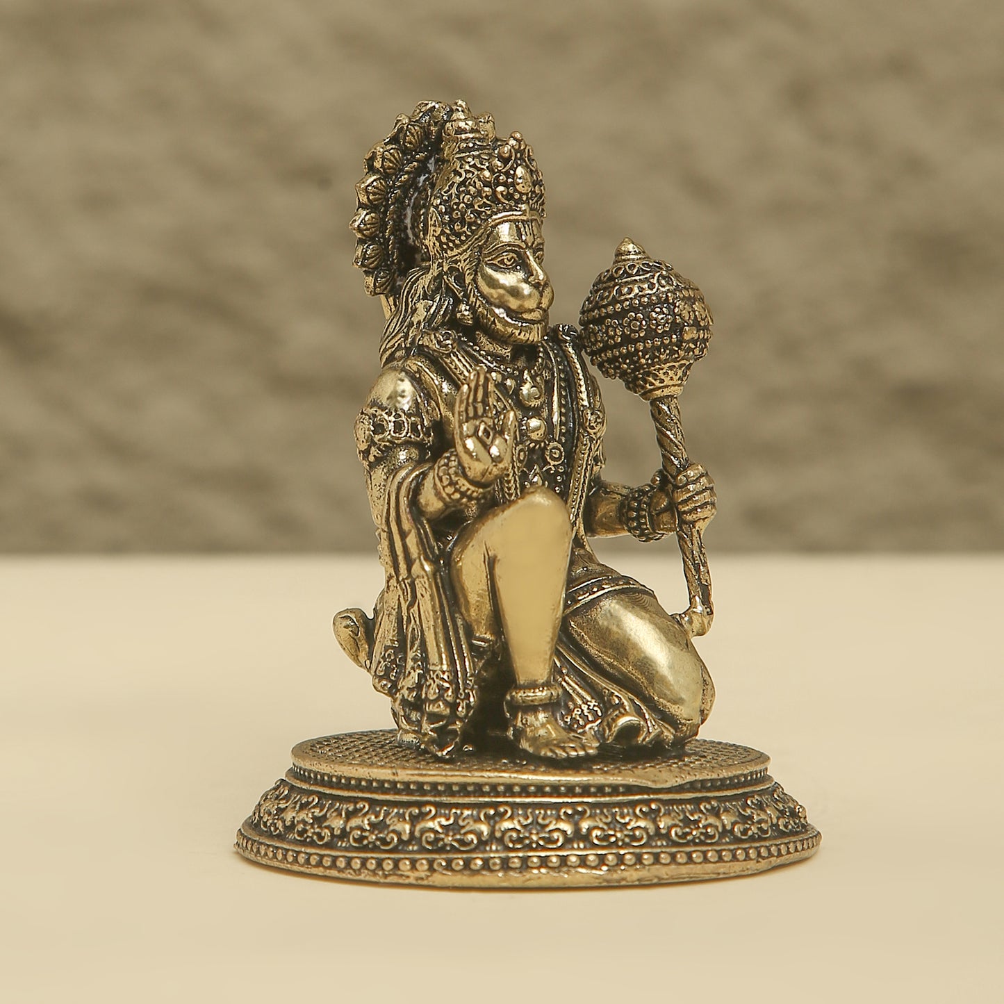Bronze statue of a deity on a beige background