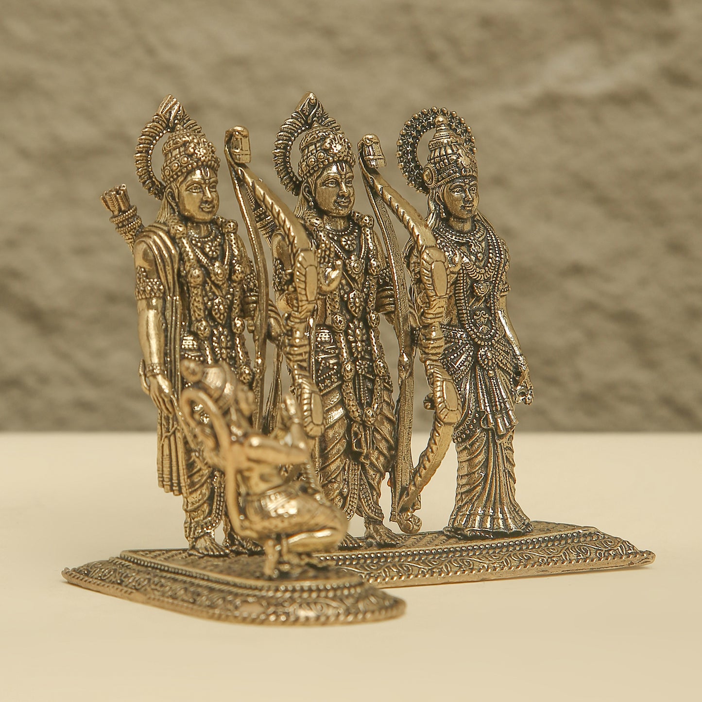 Bronze figurine of three deities on a plain background