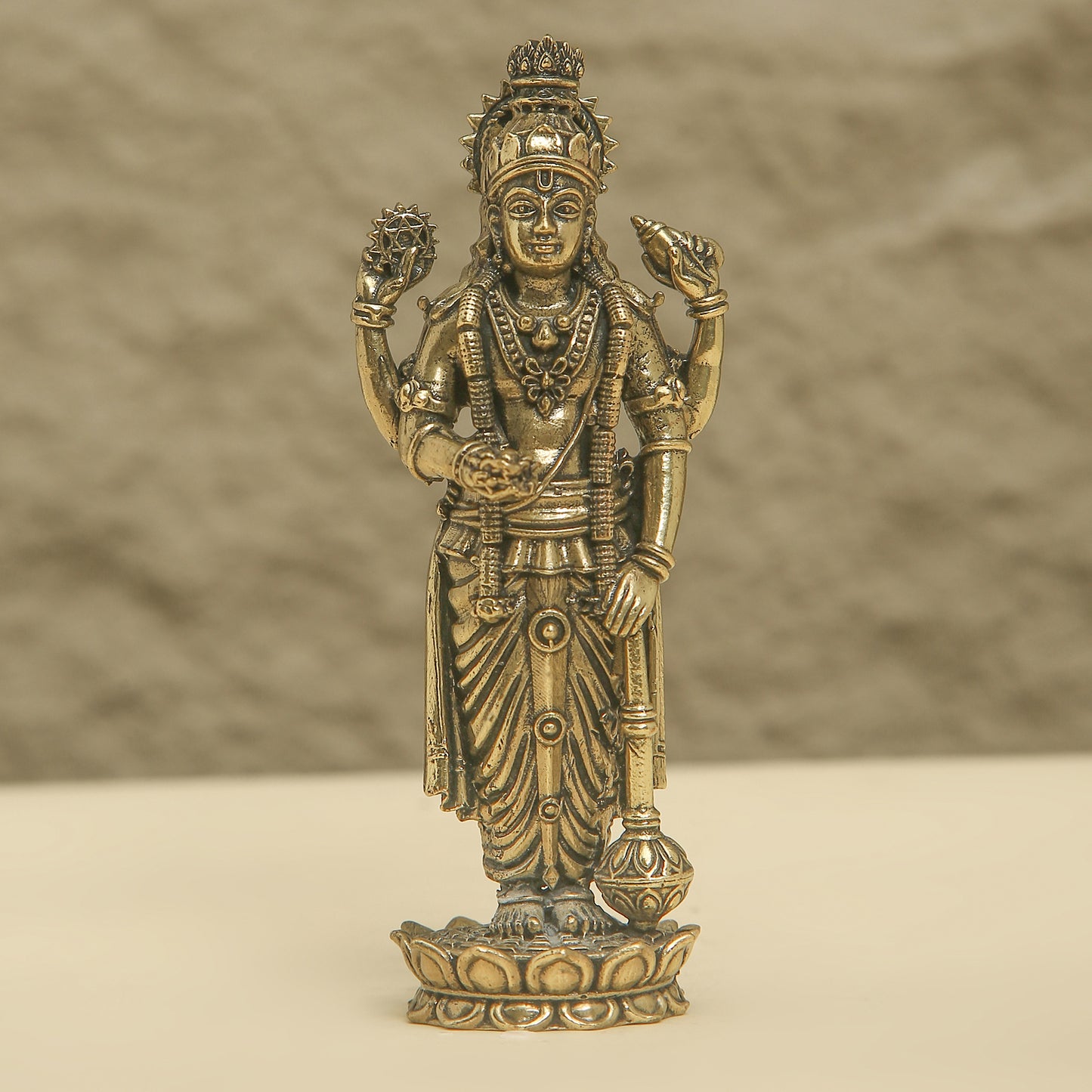 Bronze statue of a deity on a beige background