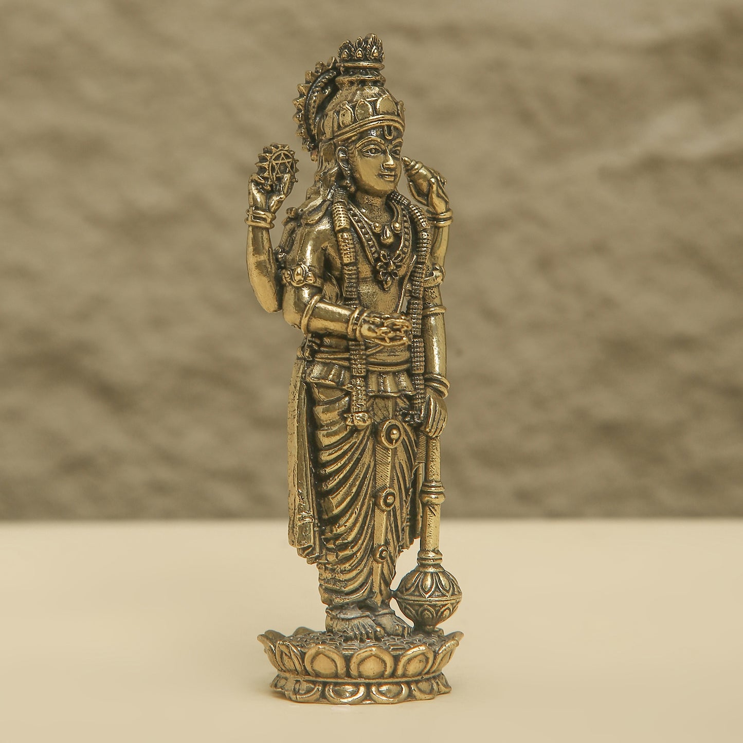 Bronze statue of a deity on a beige background