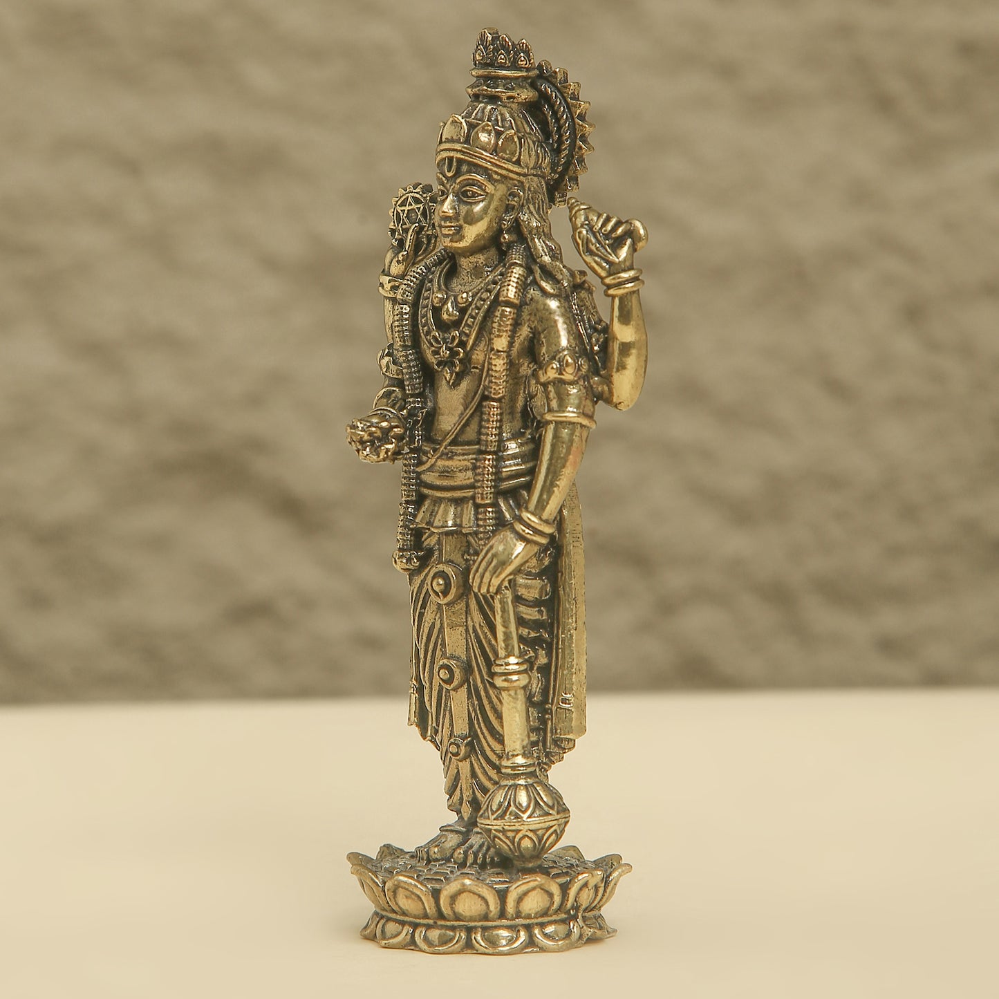 Bronze statue of a deity on a beige background