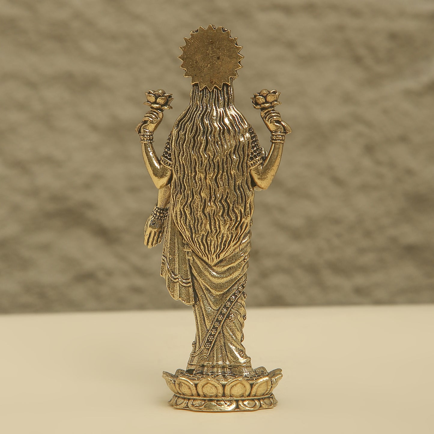 Bronze statue of a deity with a textured background