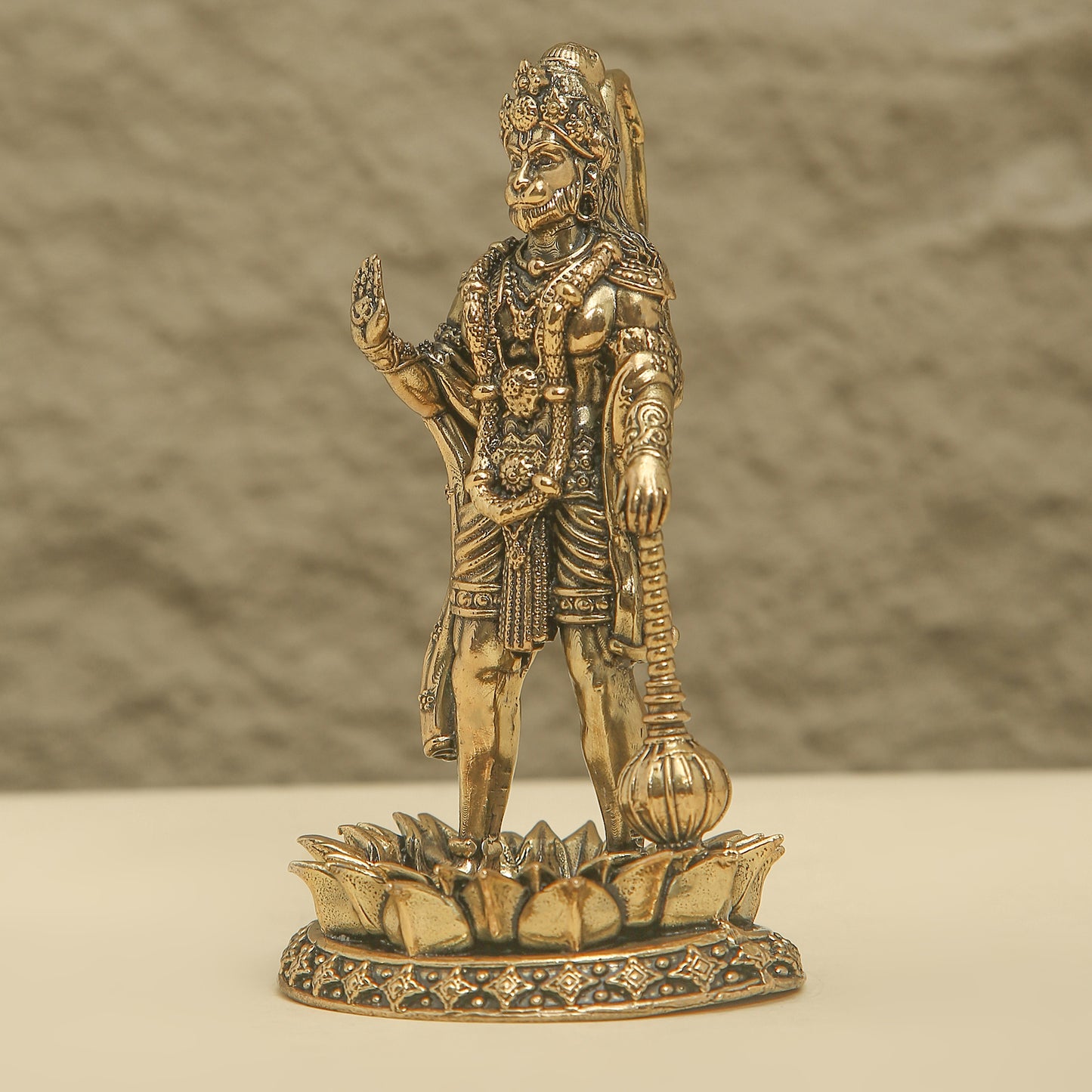 Bronze statue of a warrior on a lotus pedestal against a neutral background