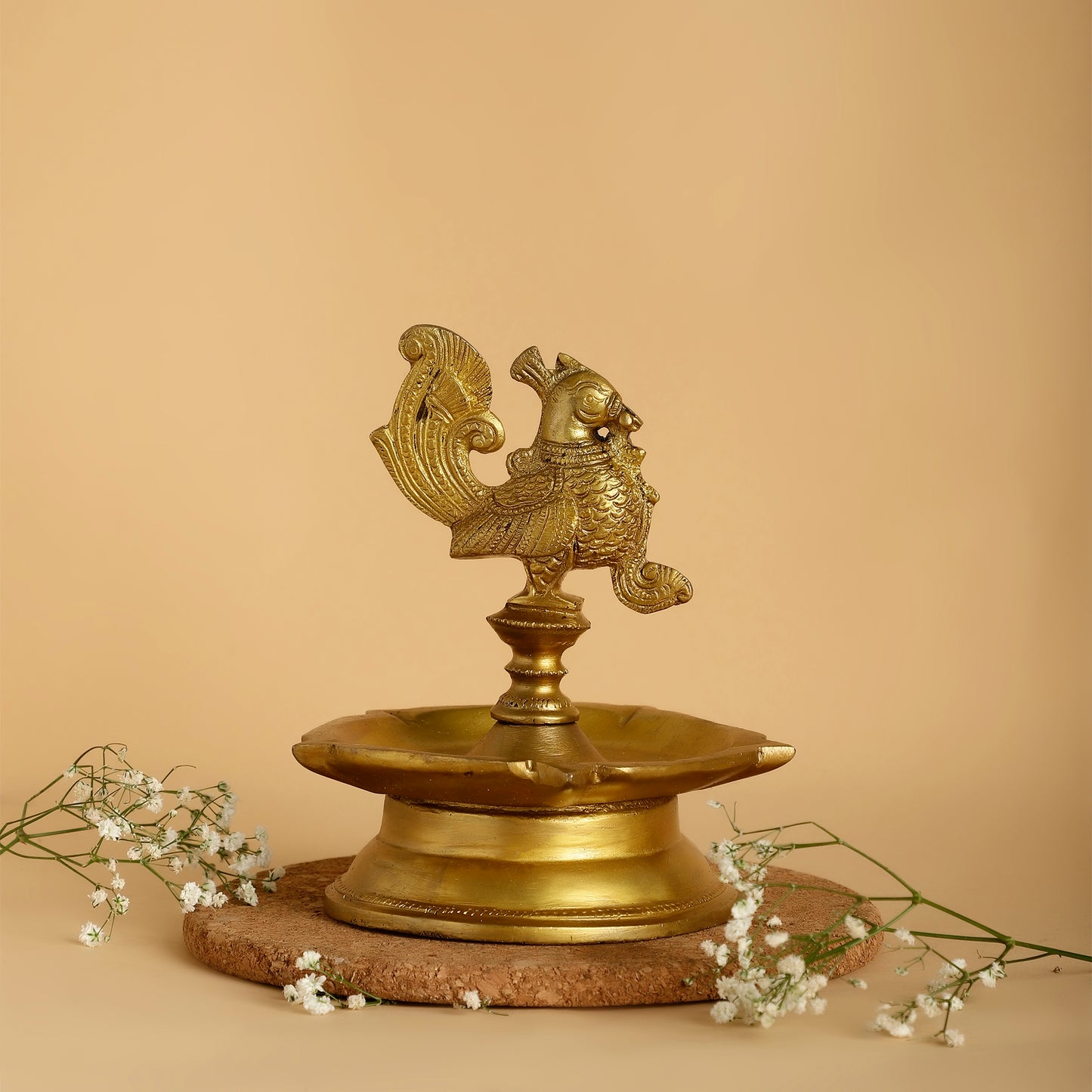 Brass lamp with rooster design on a beige background