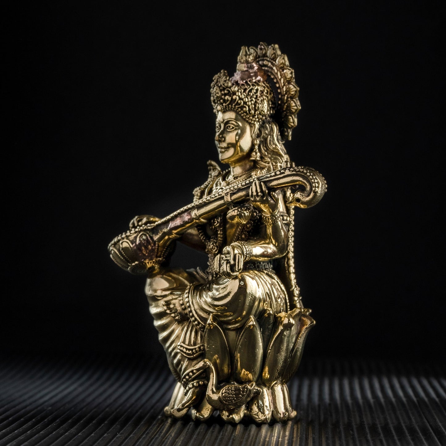 Gold-colored statue of a deity on a black background