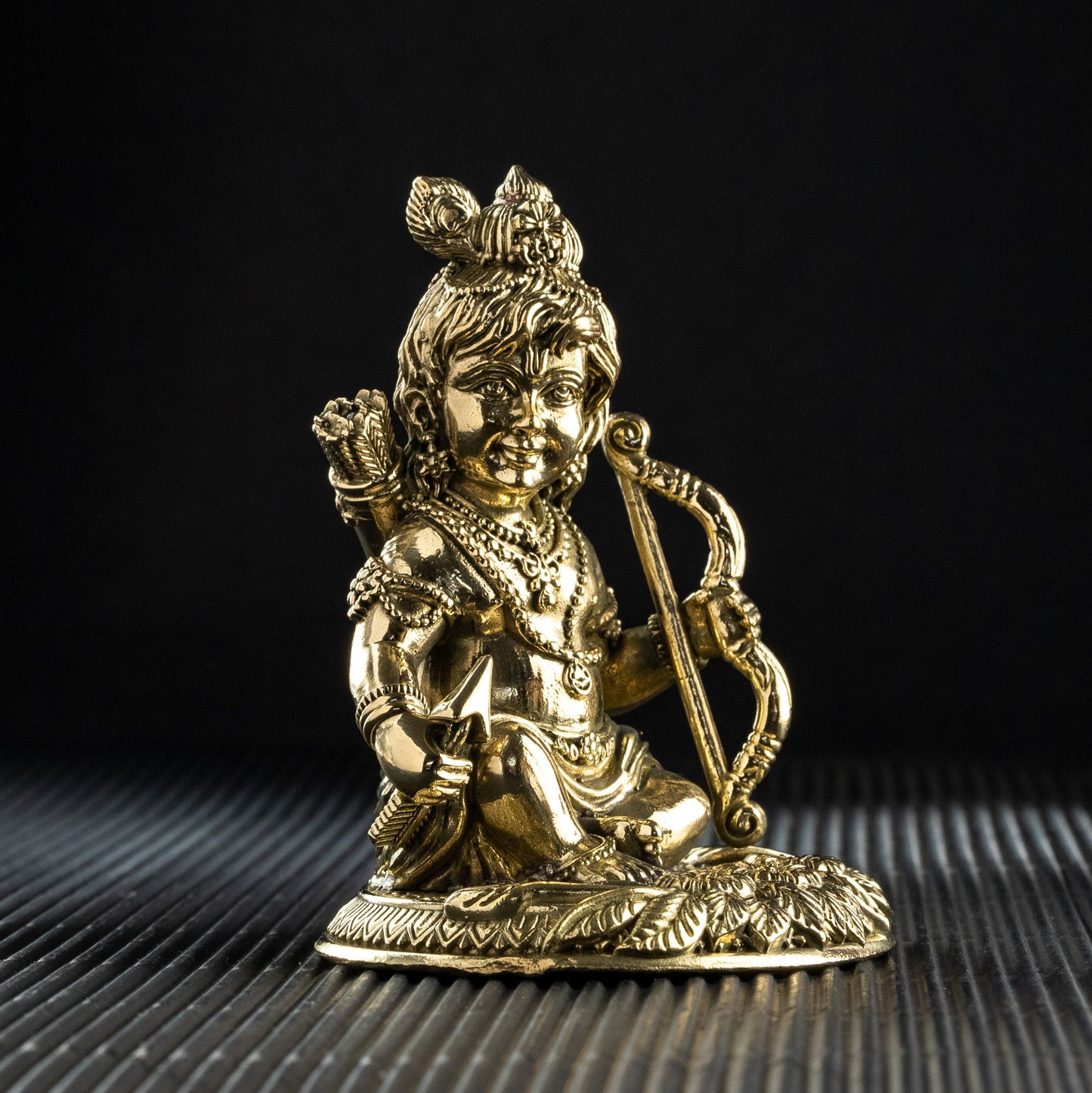 Gold-colored statue of a deity on a black background