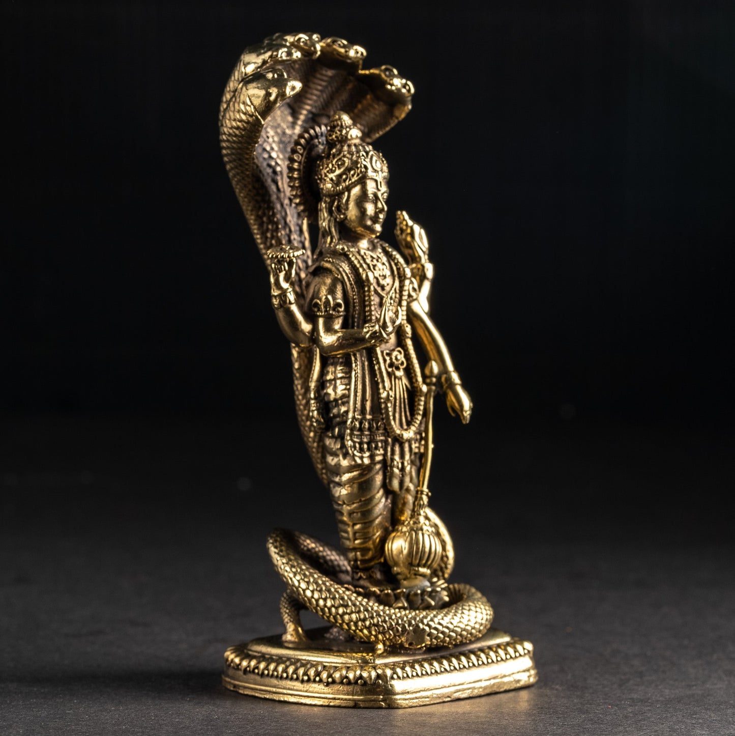 Gold figurine of a warrior with a helmet and sword on a black background