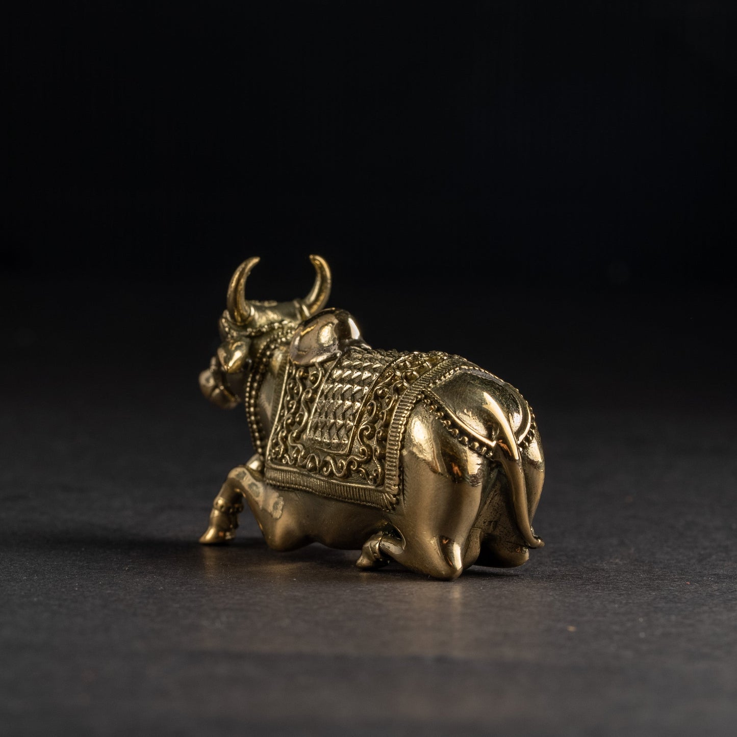 Bronze bull figurine on a dark background