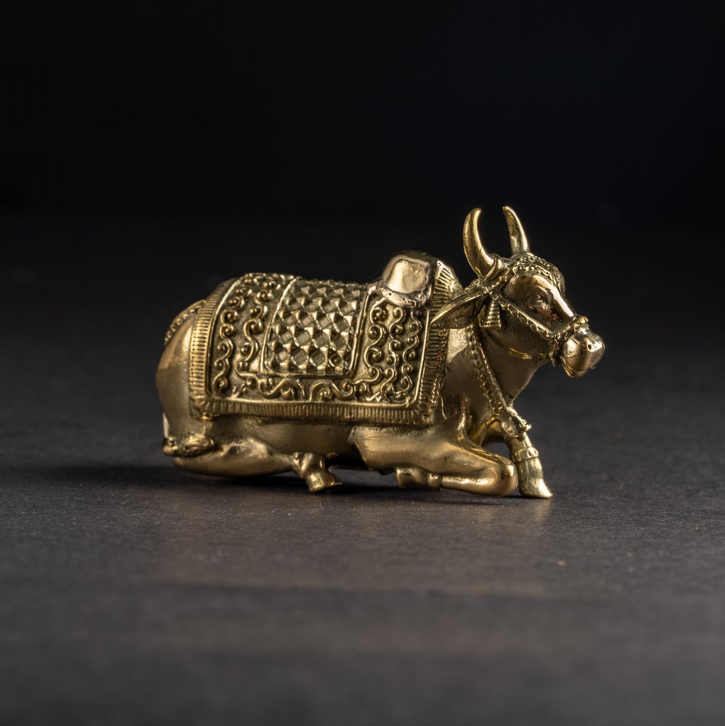 Bronze bull figurine on a black background