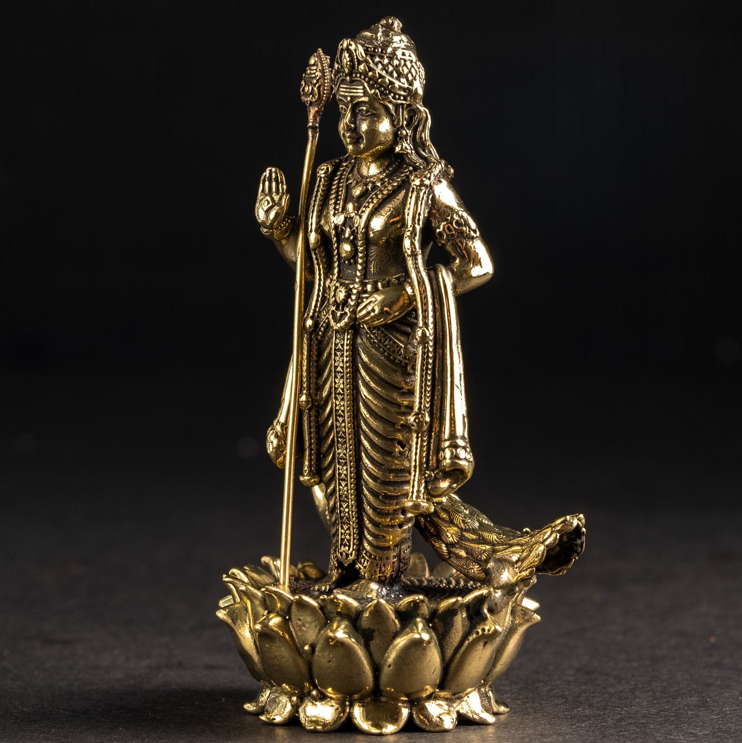 Gold-colored statue of a deity on a dark background