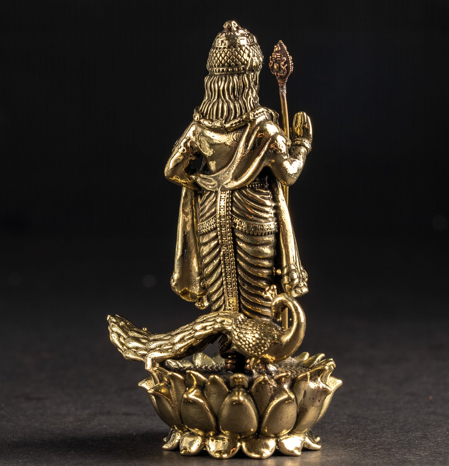 Gold-colored statue of a deity on a dark background