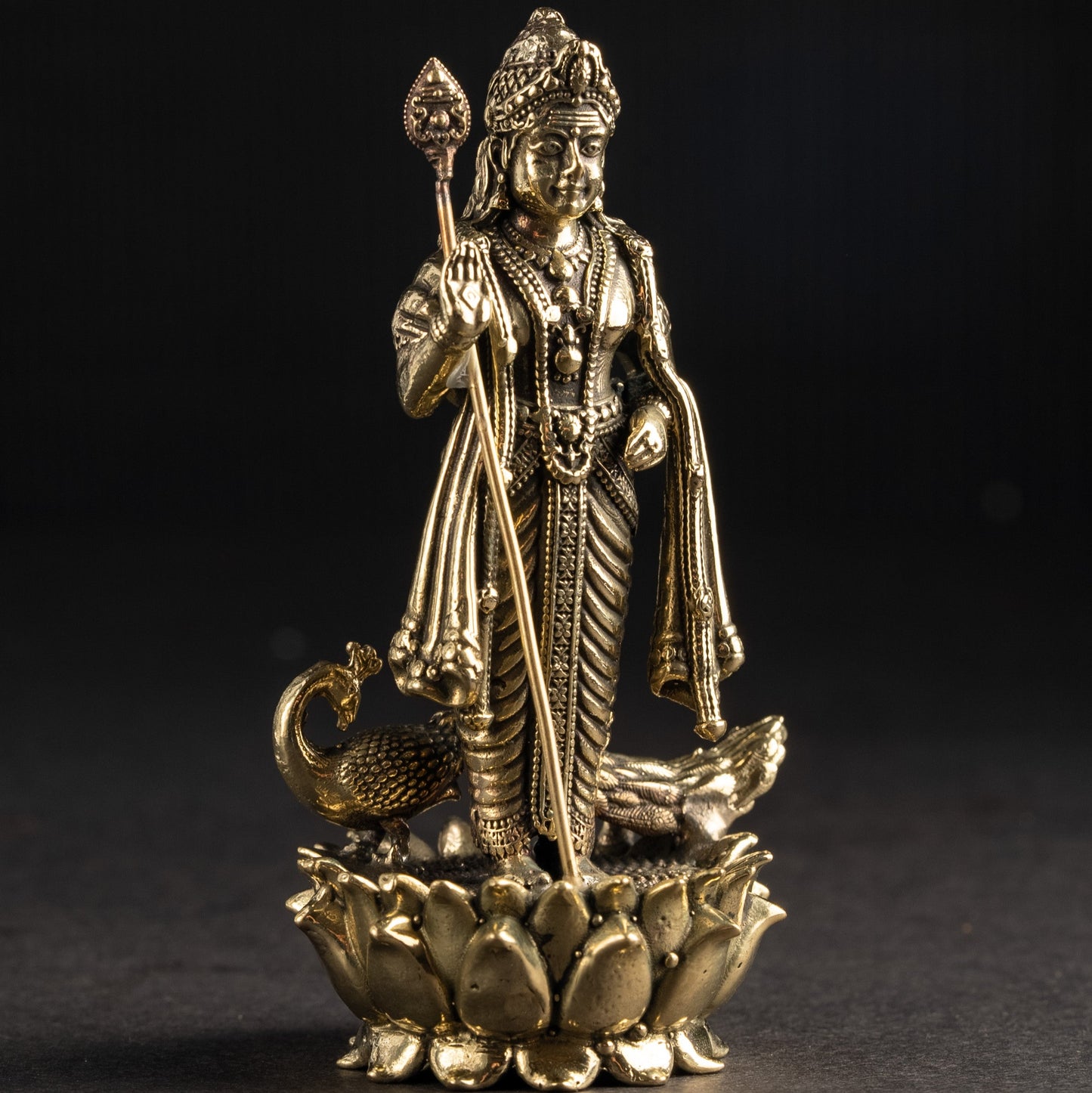 Gold-colored statue of a deity on a dark background