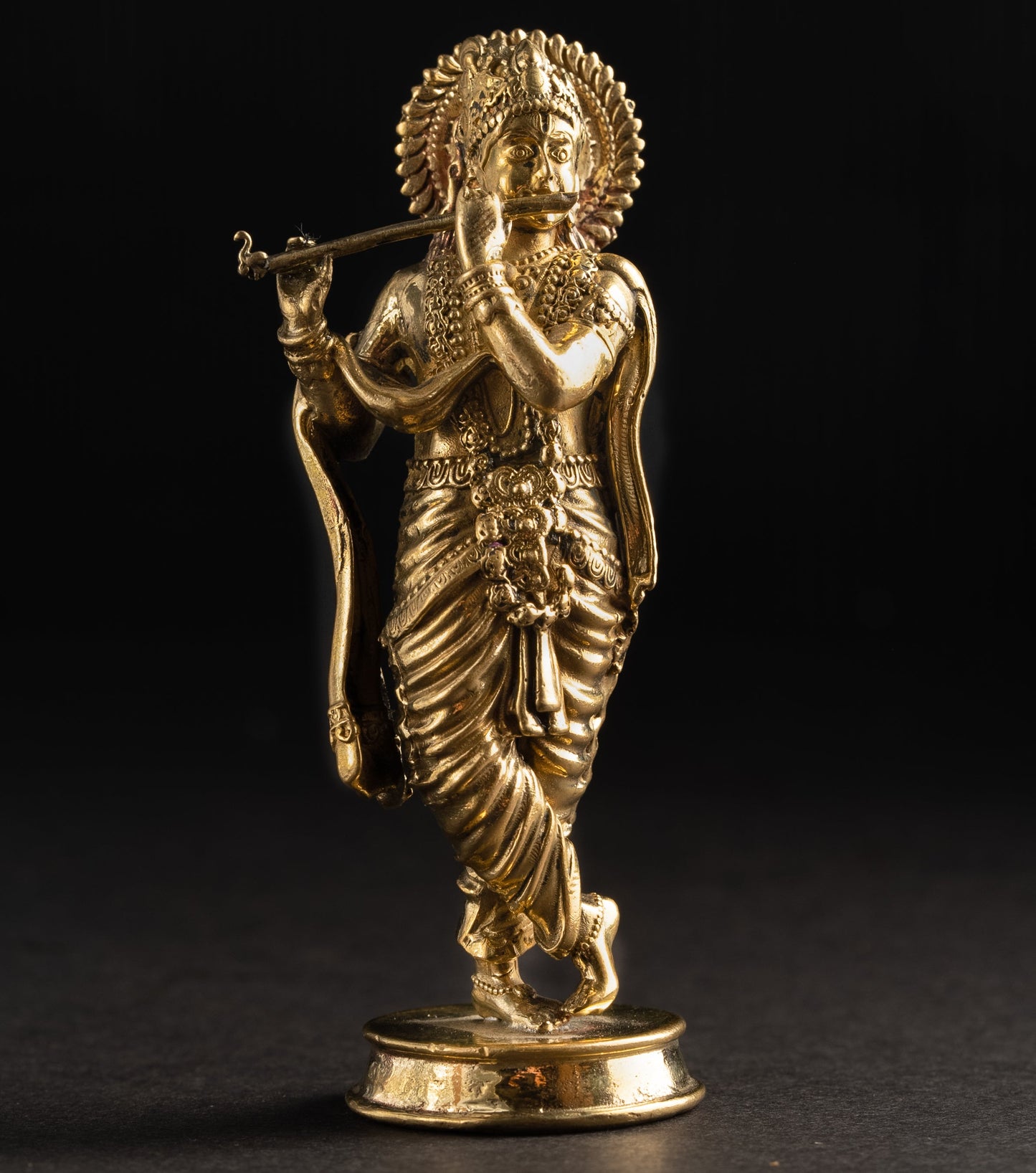 Gold statue of a deity on a black background