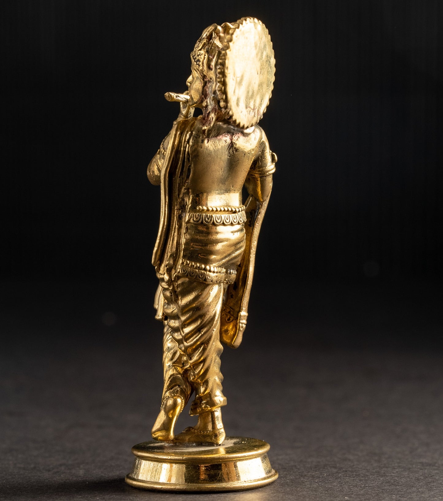 Gold-colored statue on a dark background