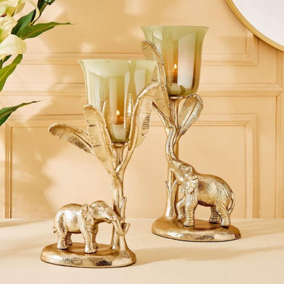 Decorative candle holders with elephant designs on a beige surface.