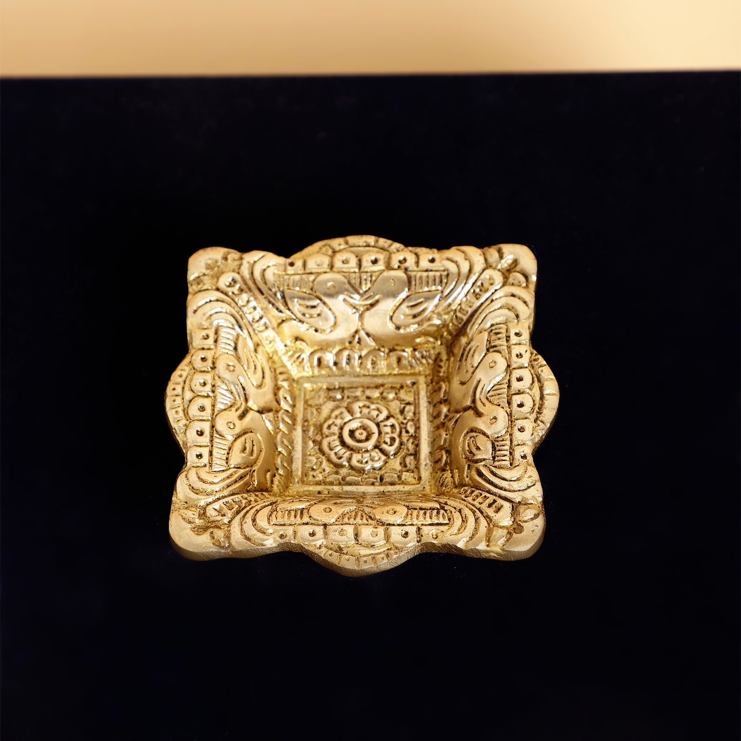 Decorative gold square object on a black background