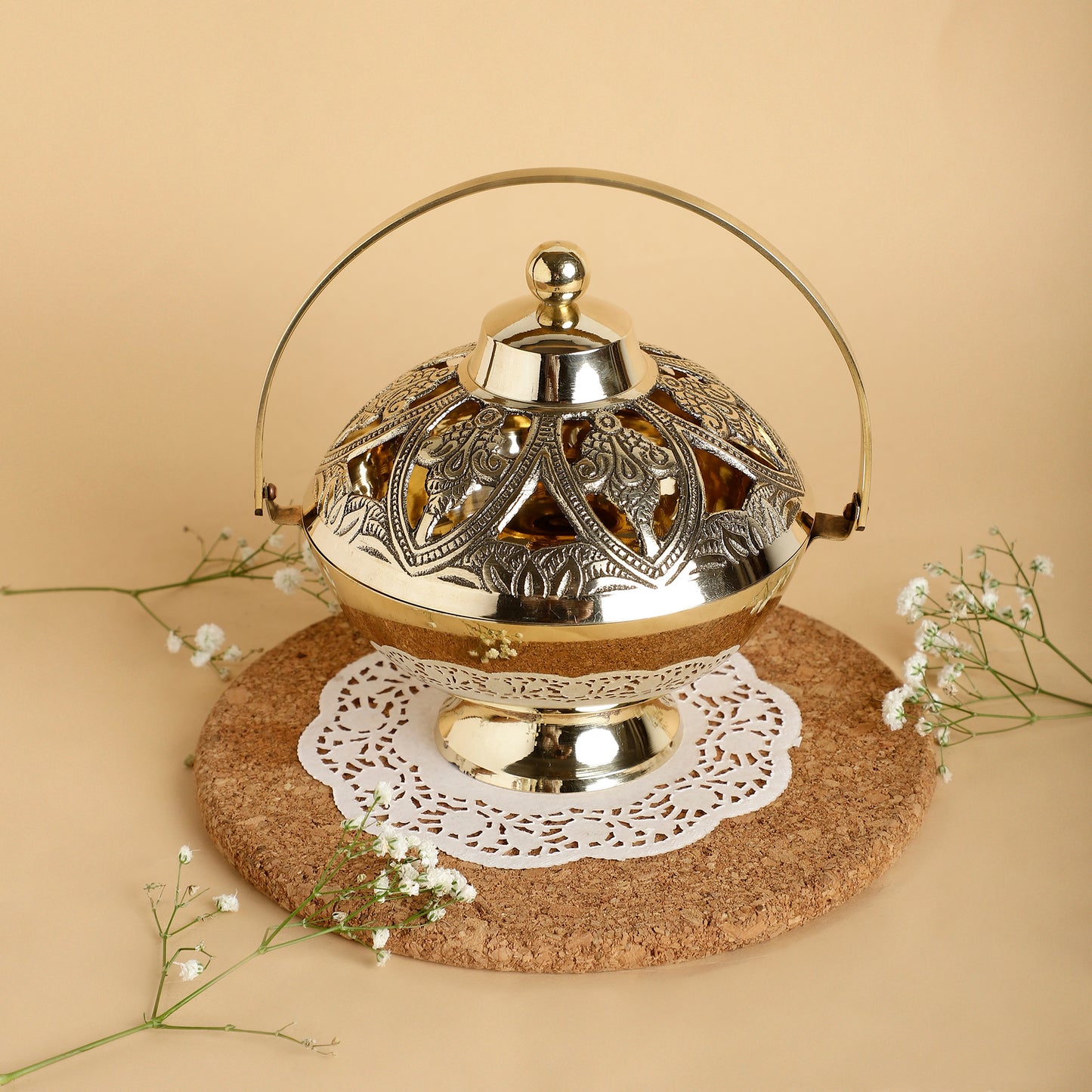 Decorative metal lantern with intricate designs on a beige background