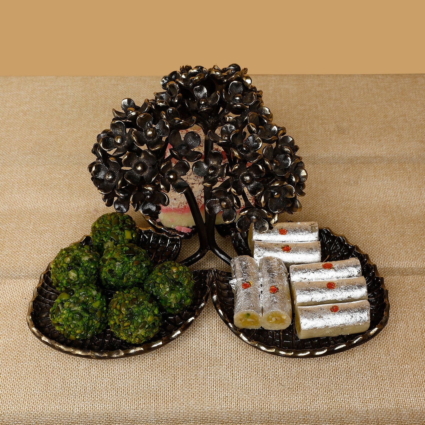 Decorative items including a small tree, green balls, and silver packets on a beige surface.