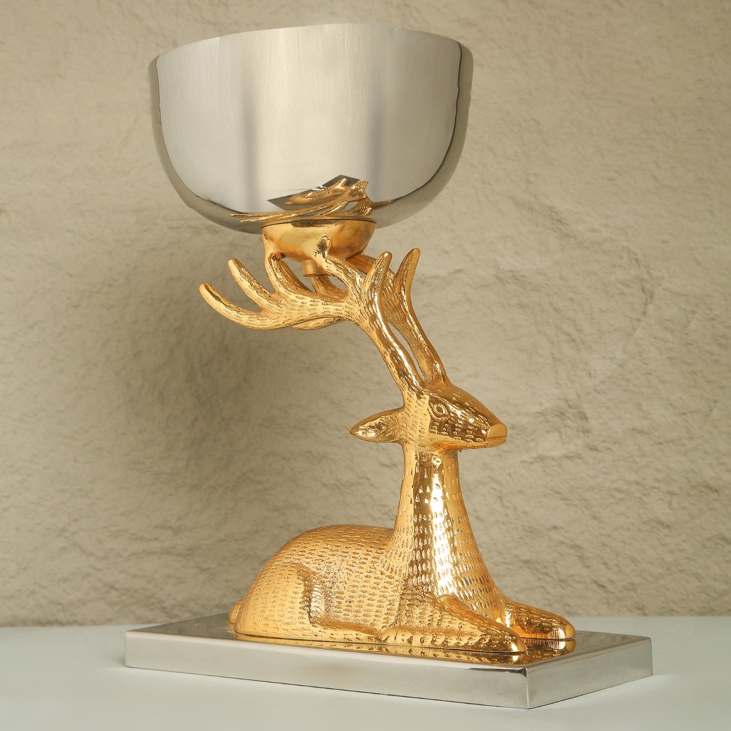 Gold deer-shaped trophy with a reflective bowl on a neutral background