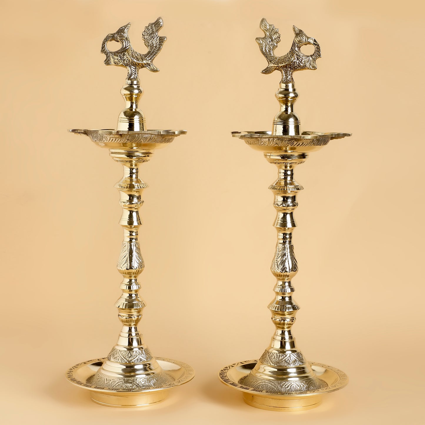 Two ornate brass lamps on a beige background