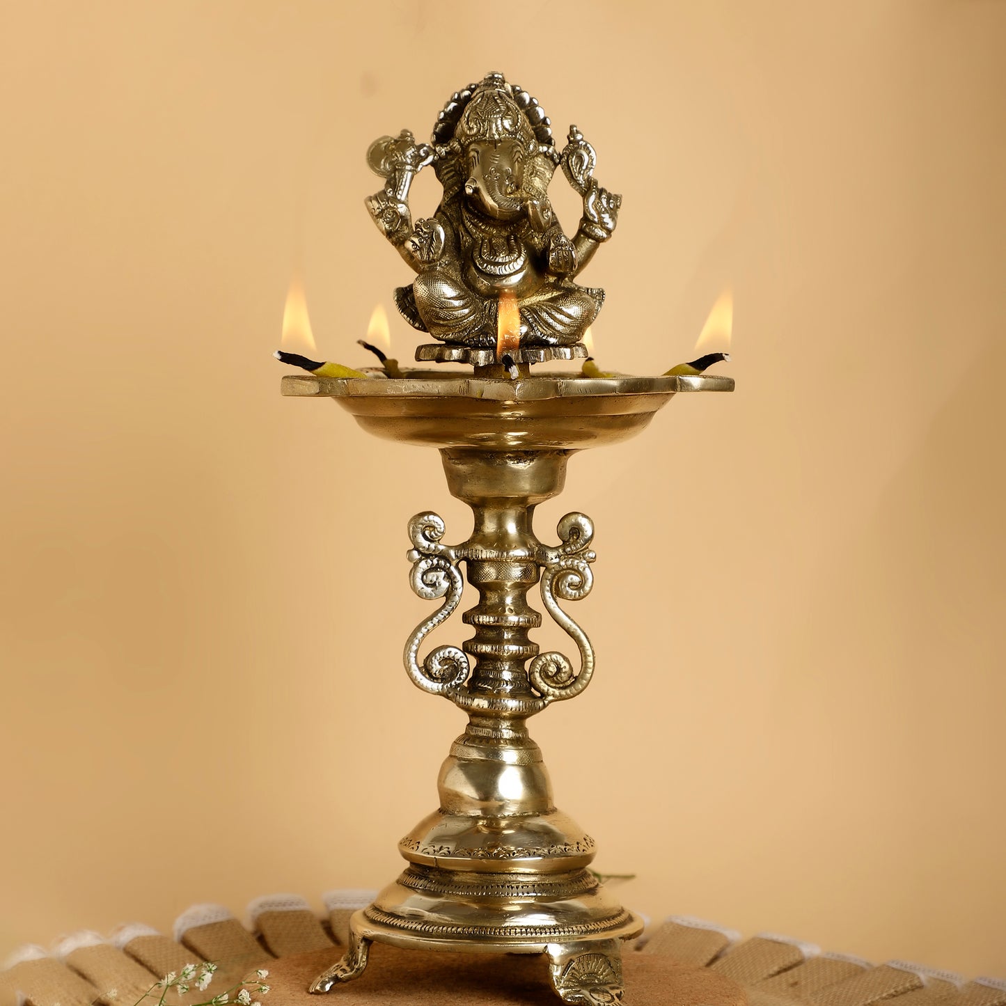 Decorative oil lamp with a figurine on top against a beige background