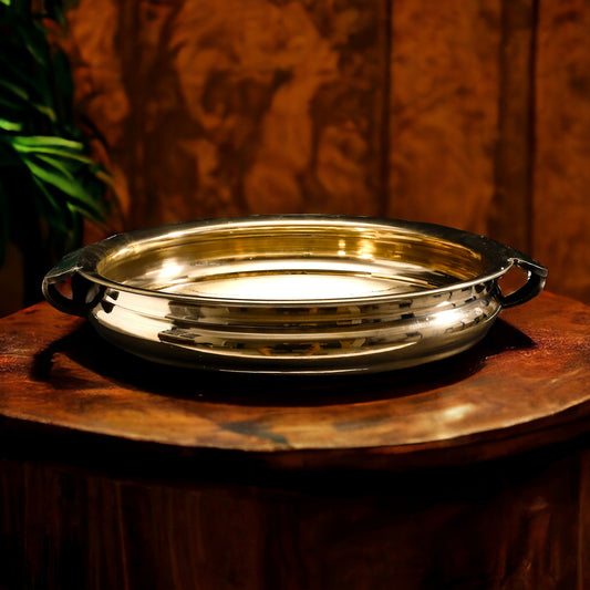 Gold tray with handles on a wooden surface
