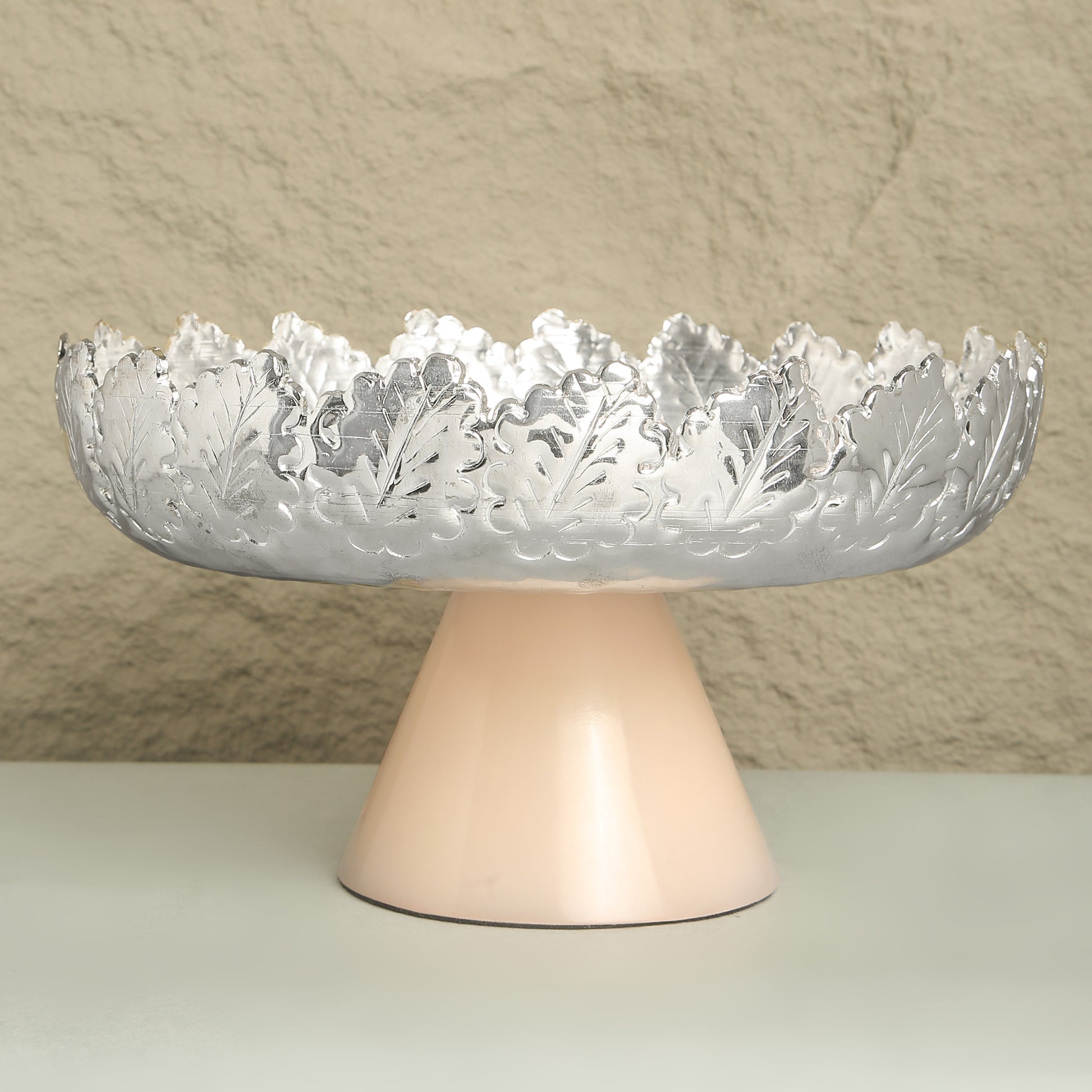 Decorative bowl with intricate design on a stand against a neutral background