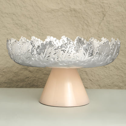 Decorative bowl with intricate design on a stand against a neutral background
